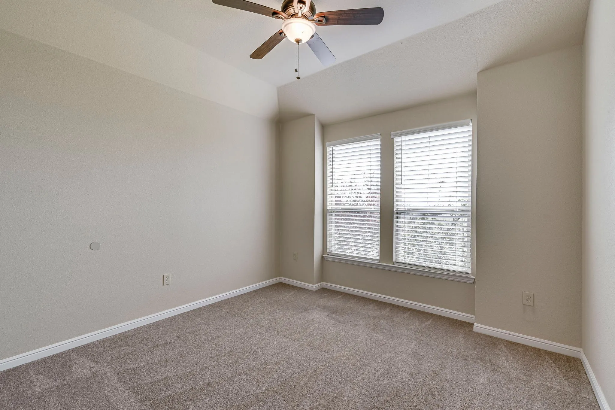 Spare room with light colored carpet, ceiling fan, and lofted ceiling