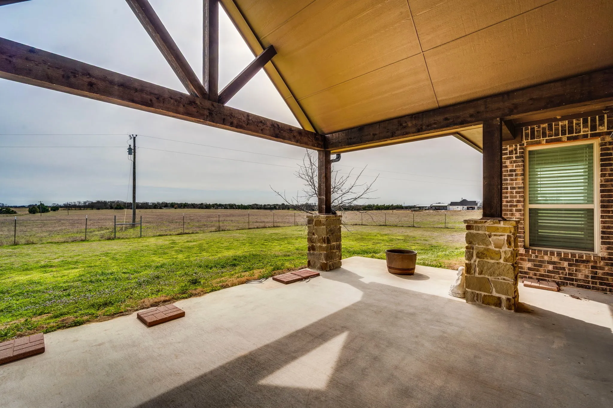 Fenced backyard featuring a patio area and a rural view