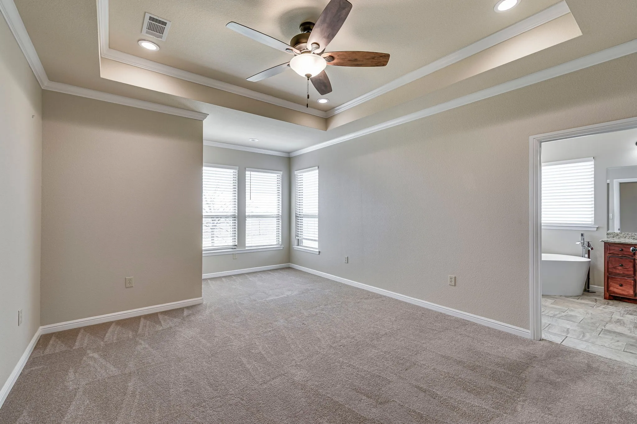 Unfurnished room with ceiling fan, a tray ceiling, recessed lighting, light carpet, and ornamental molding