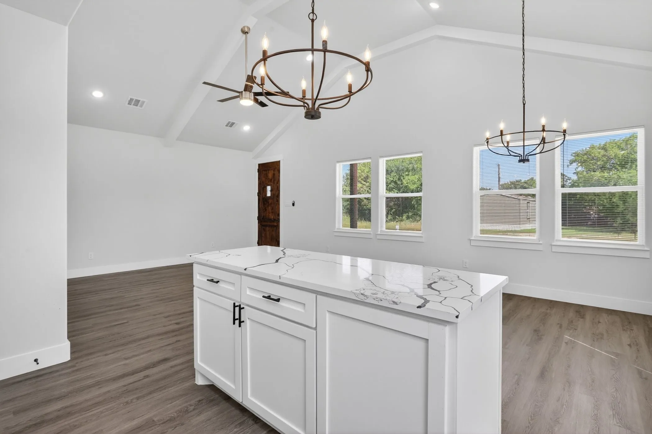 Central kitchen island with a patterned countertop and white cabinetry