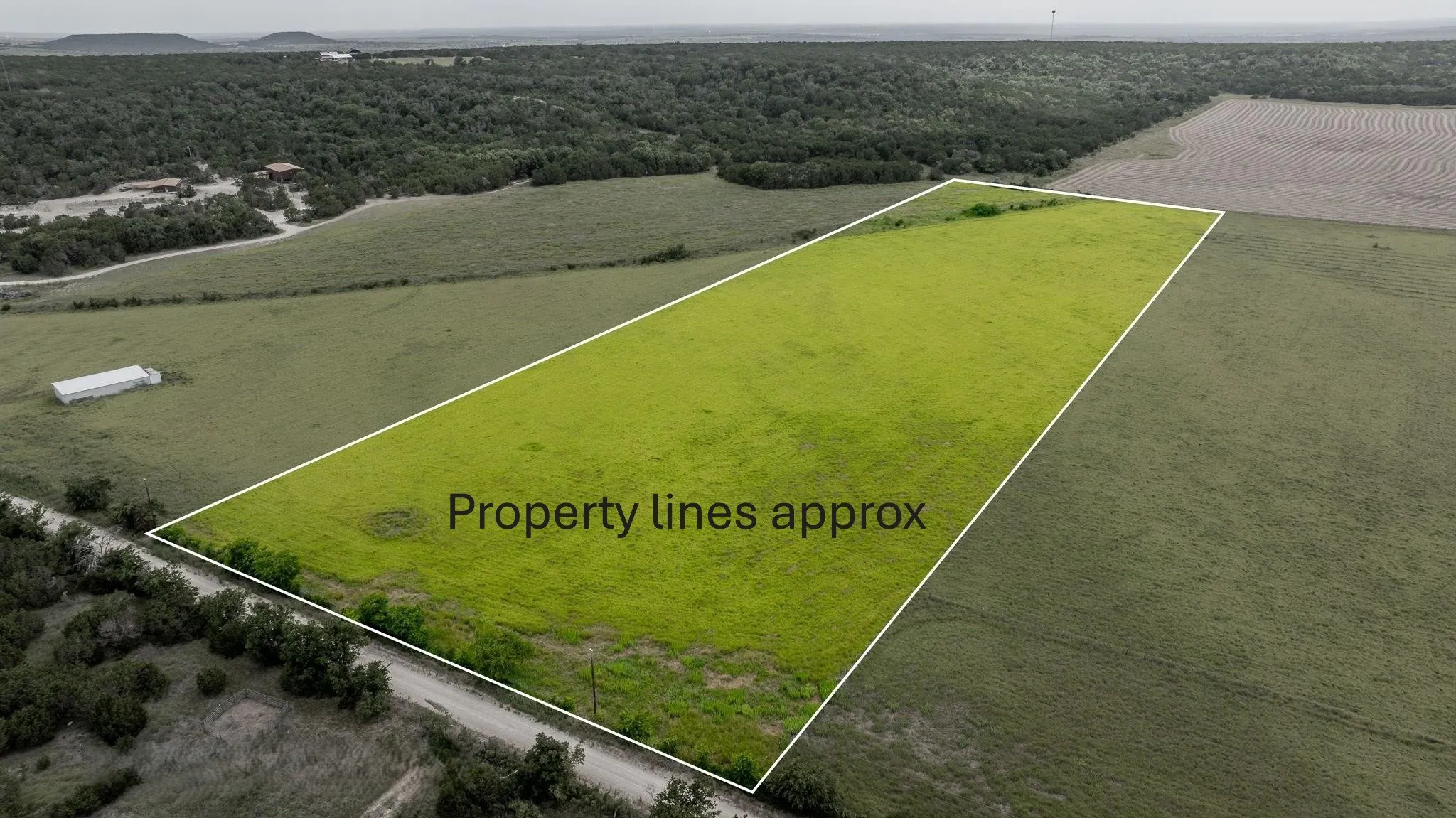 Overview of rural landscape featuring property boundaries highlighted and a heavily wooded area