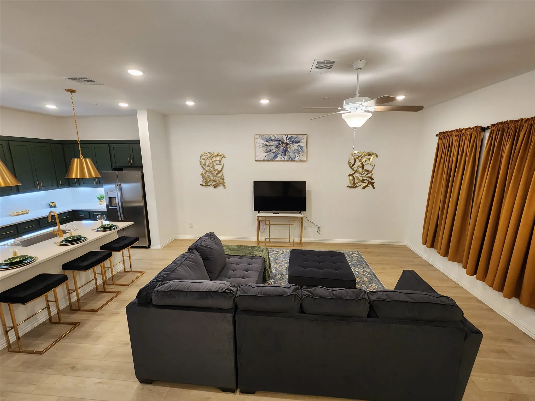 Living room featuring light wood finished floors, recessed lighting, and ceiling fan