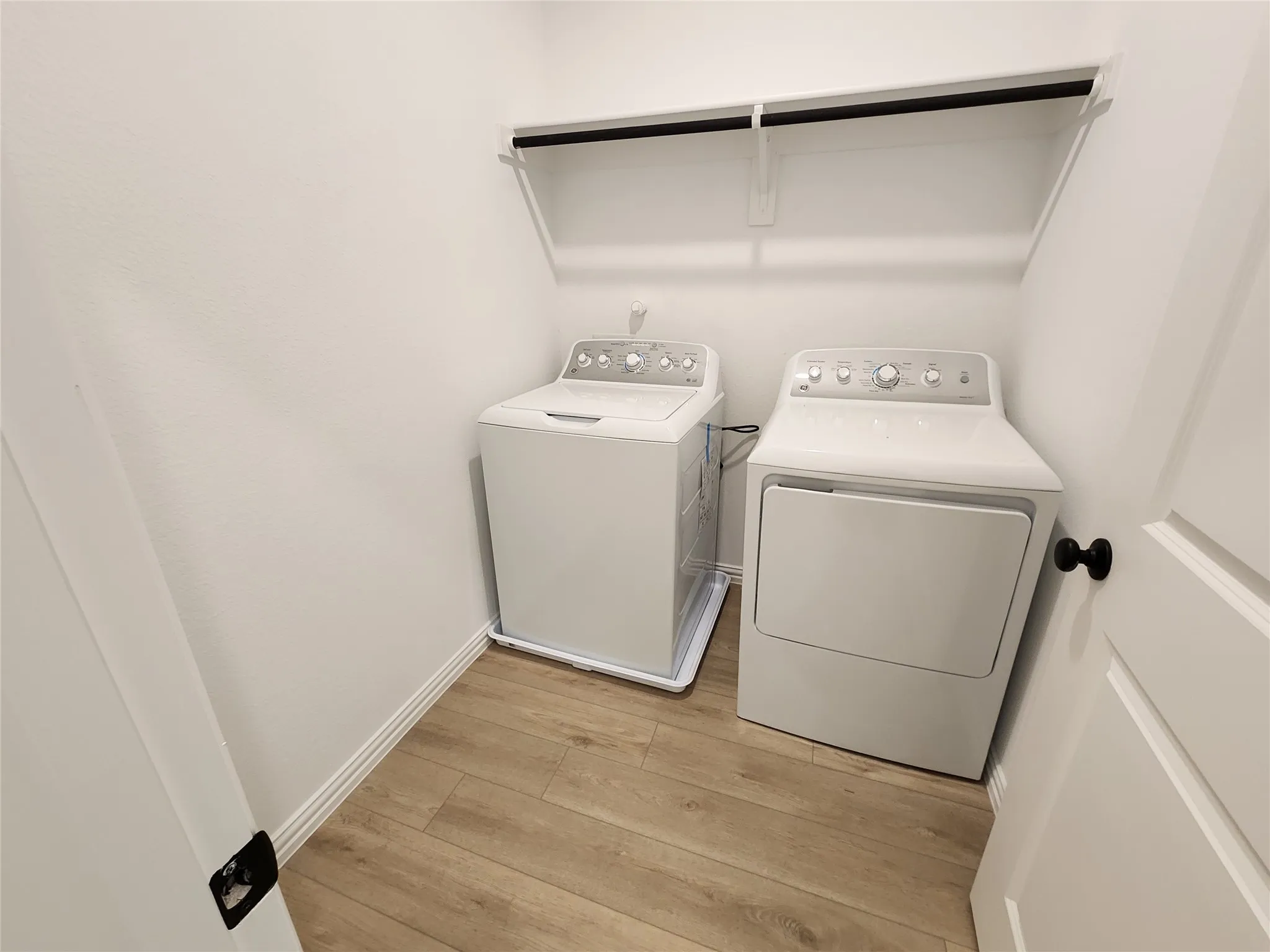 Laundry room featuring light wood-style floors and washer and dryer