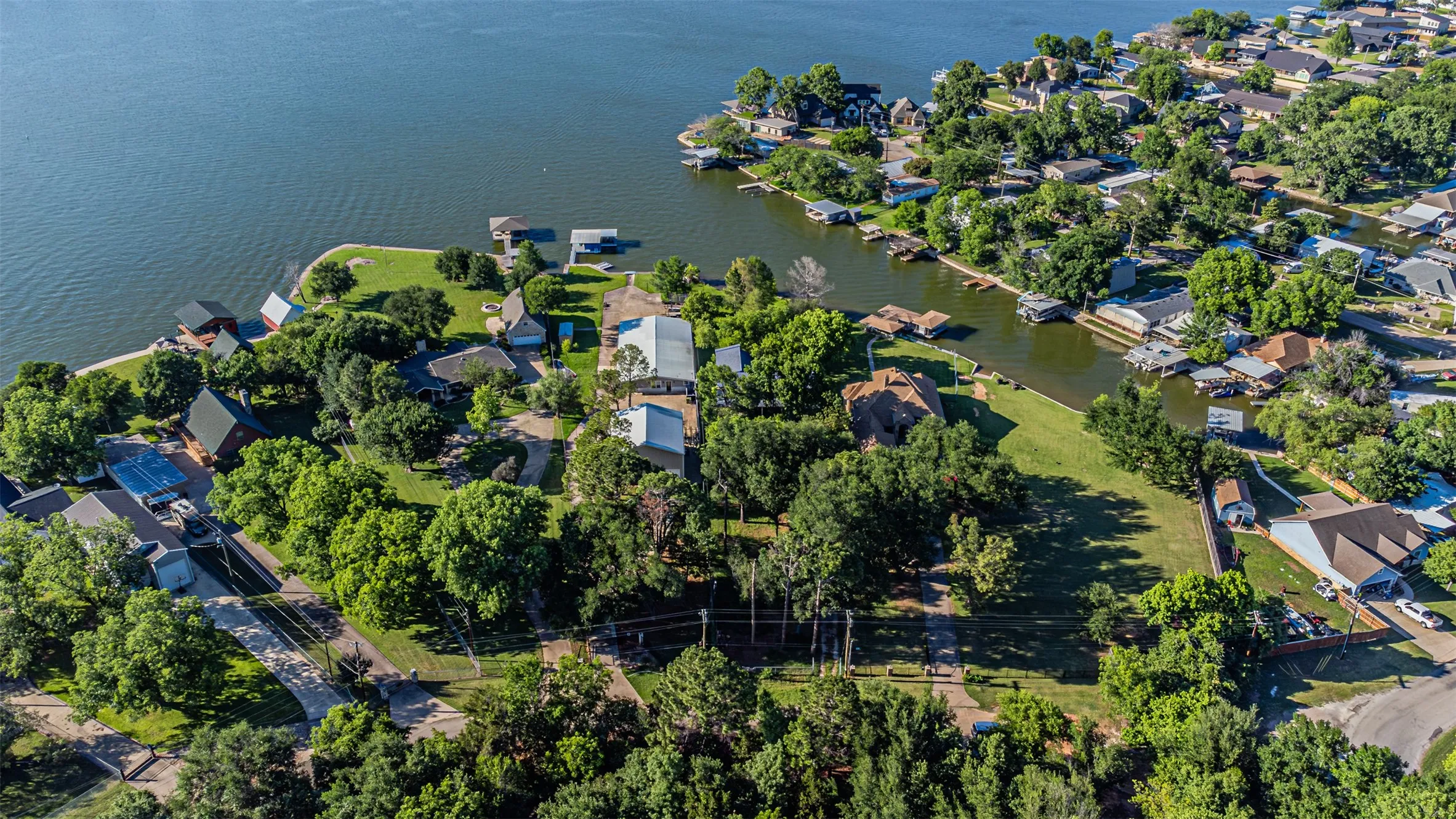 Aerial perspective showcasing a waterfront community with extensive tree coverage