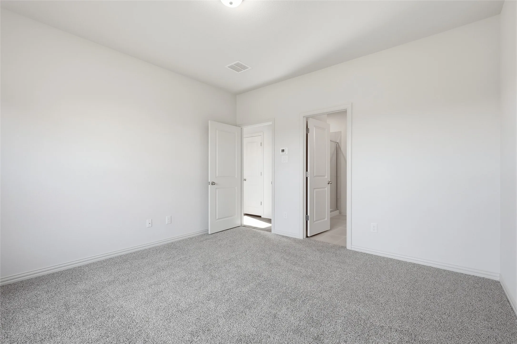 Carpeted room with light gray walls, white trim, and a ceiling-mounted light fixture