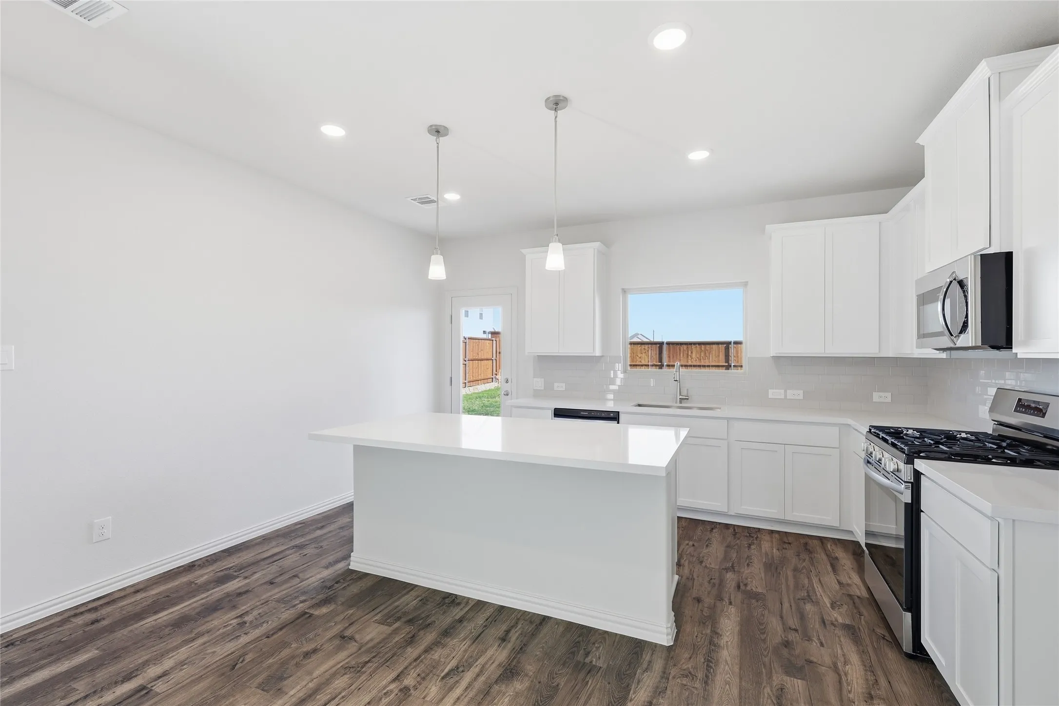 Contemporary kitchen featuring a bright white island, coordinating cabinetry, and stainless steel appliances