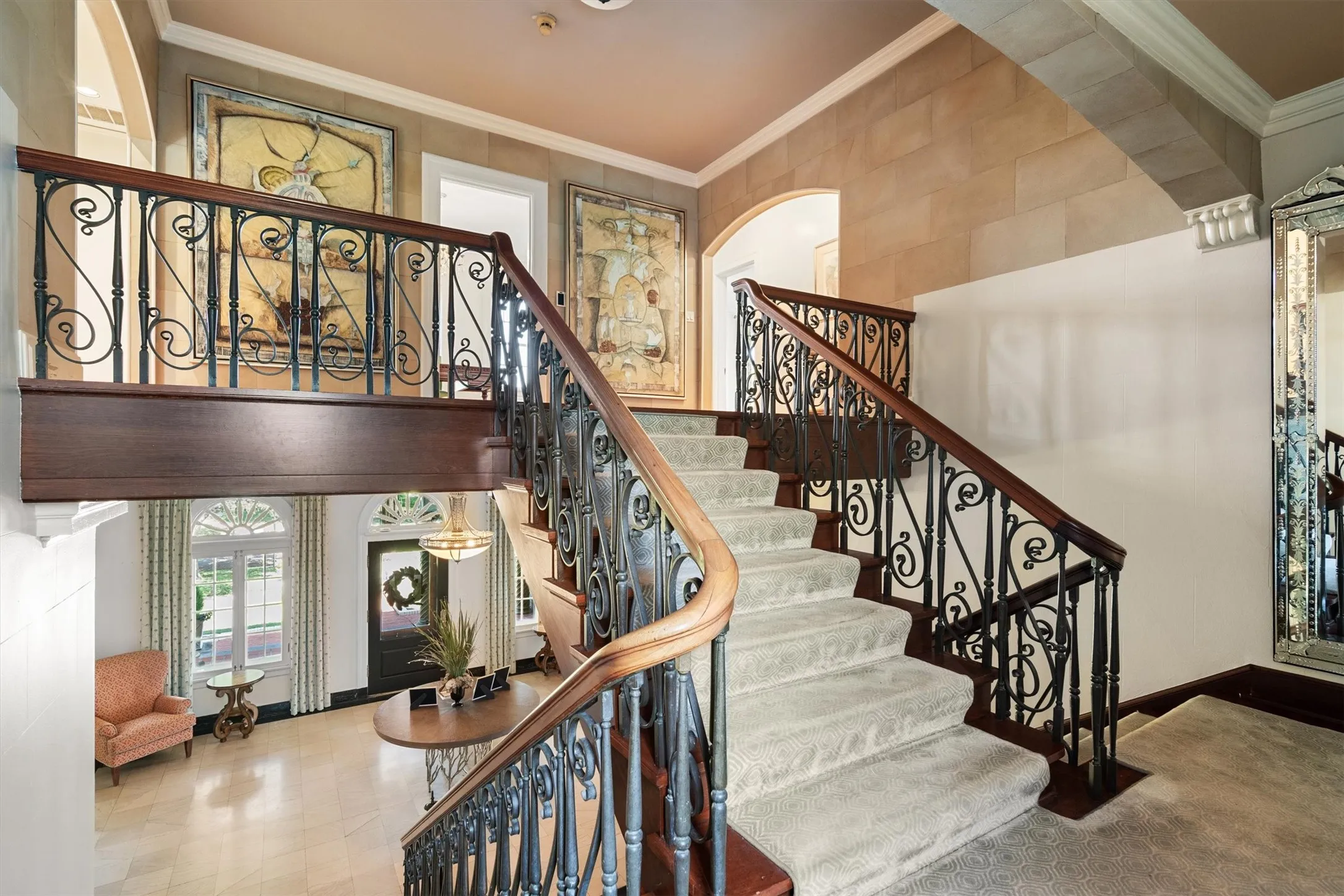 A grand staircase rises gracefully from the entry, leading to the second-floor living quarters. Rich wood steps are complemented by elegant wrought
iron balusters, creating a striking centerpiece that
blends craftsmanship with timeless sophistication.