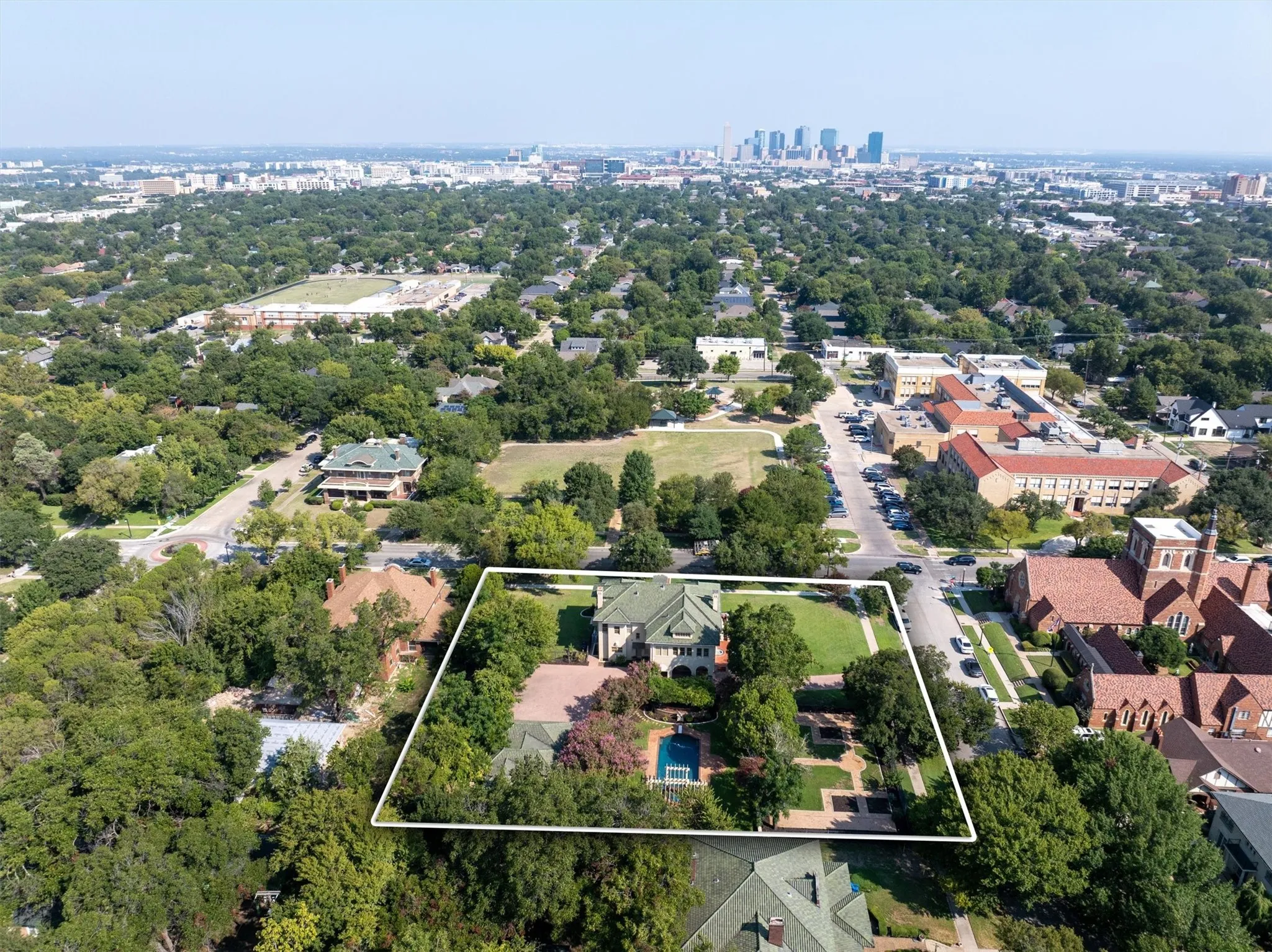 This aerial view highlights the property parcel outlined within a dynamic urban area, while also showcasing the nearby suburban neighborhood and
location to downtown.