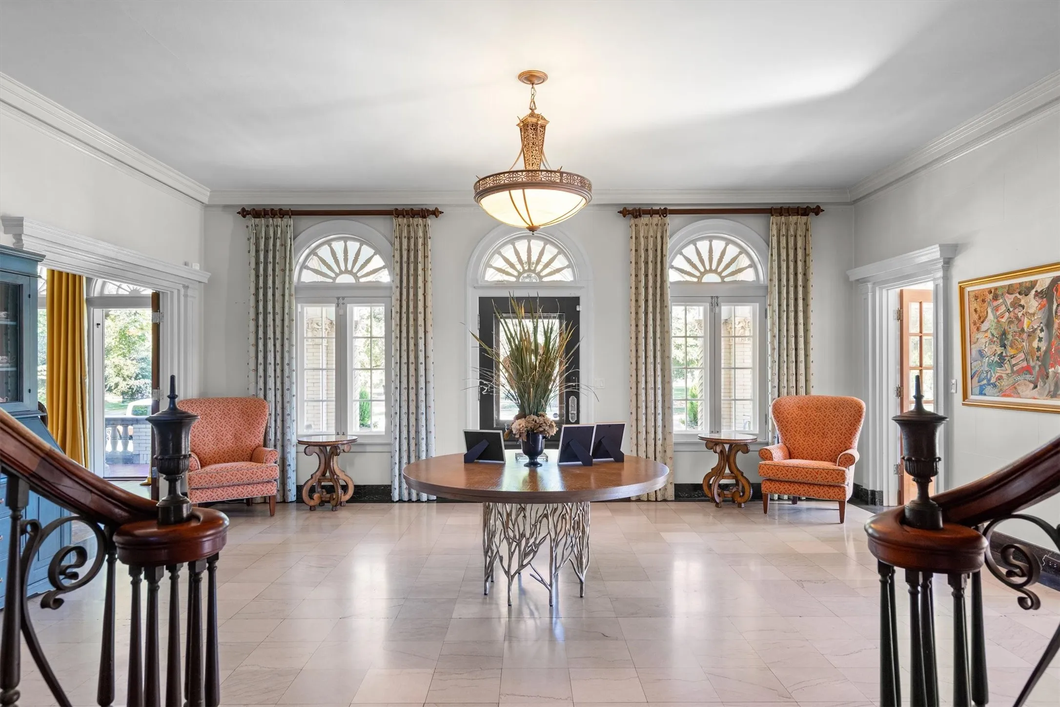 This elegant entryway features soaring ceilings,
grand arched windows, and a sweeping staircase
that sets the tone for the home’s timeless
sophistication.