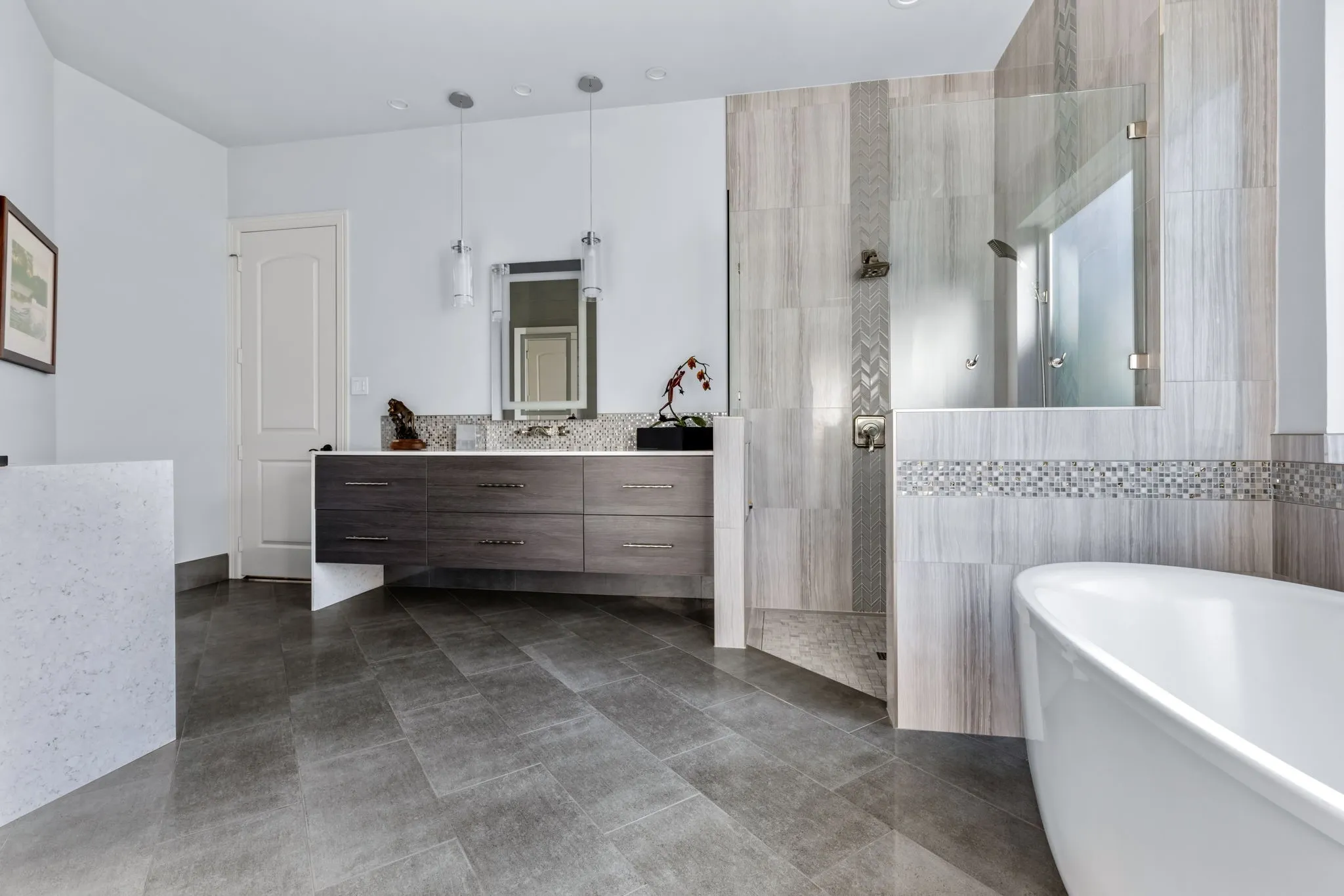 Bathroom with a soaking tub, vanity, tile walls, dark tile patterned flooring, and a shower stall