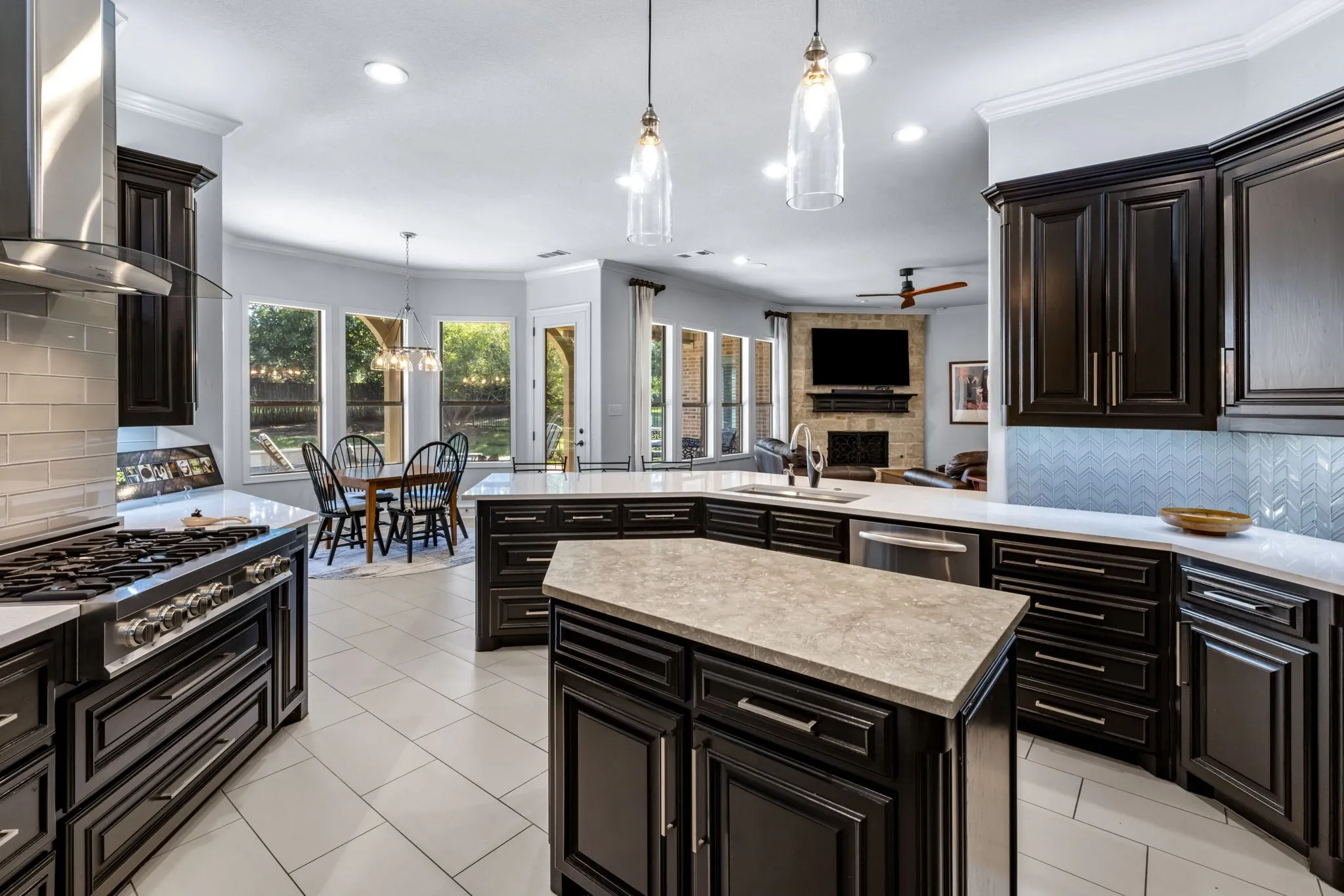 Kitchen featuring decorative backsplash, range hood, pendant lighting, crown molding, and a kitchen island