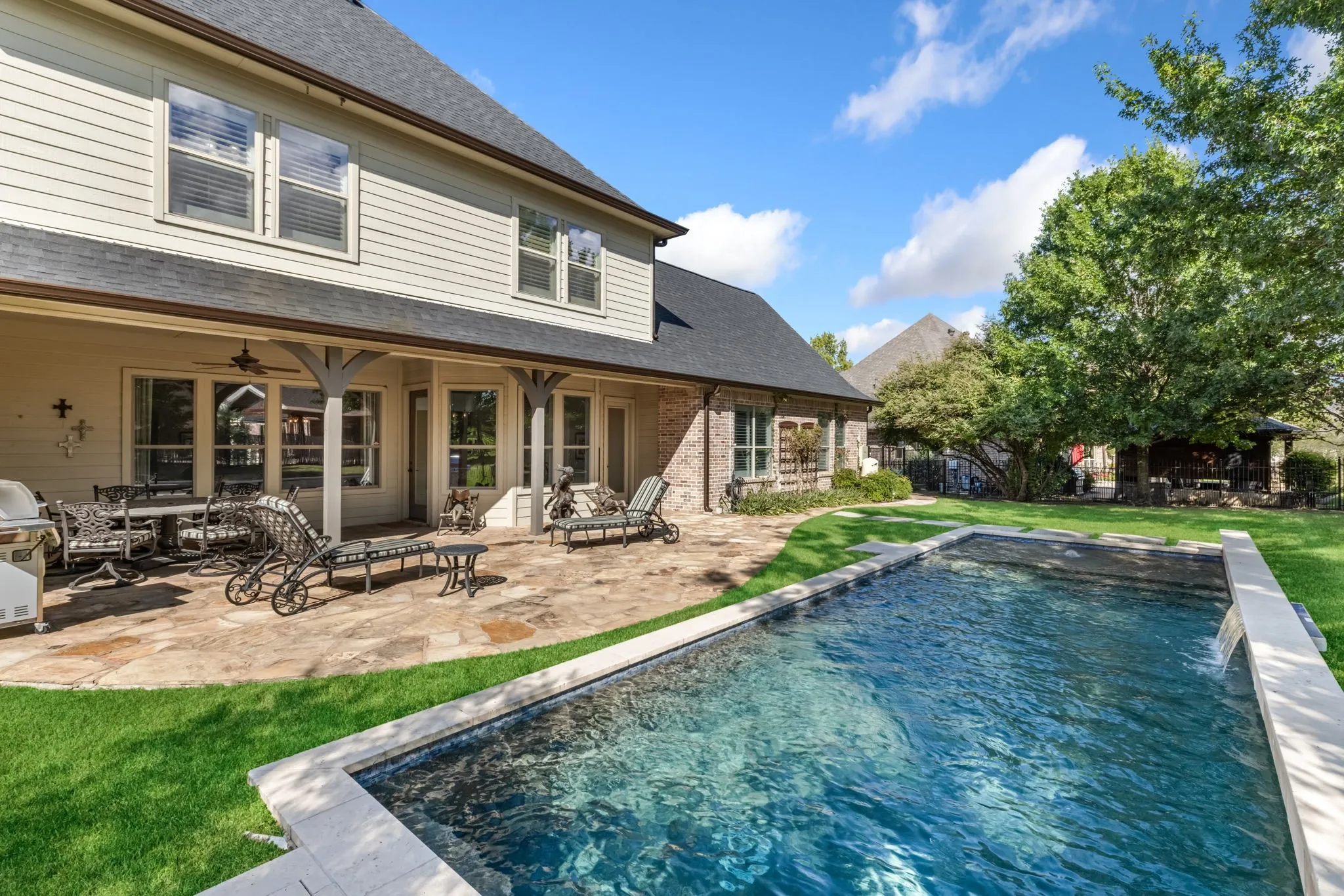 Back of house featuring roof with shingles, a patio, a ceiling fan, an outdoor pool, and brick siding