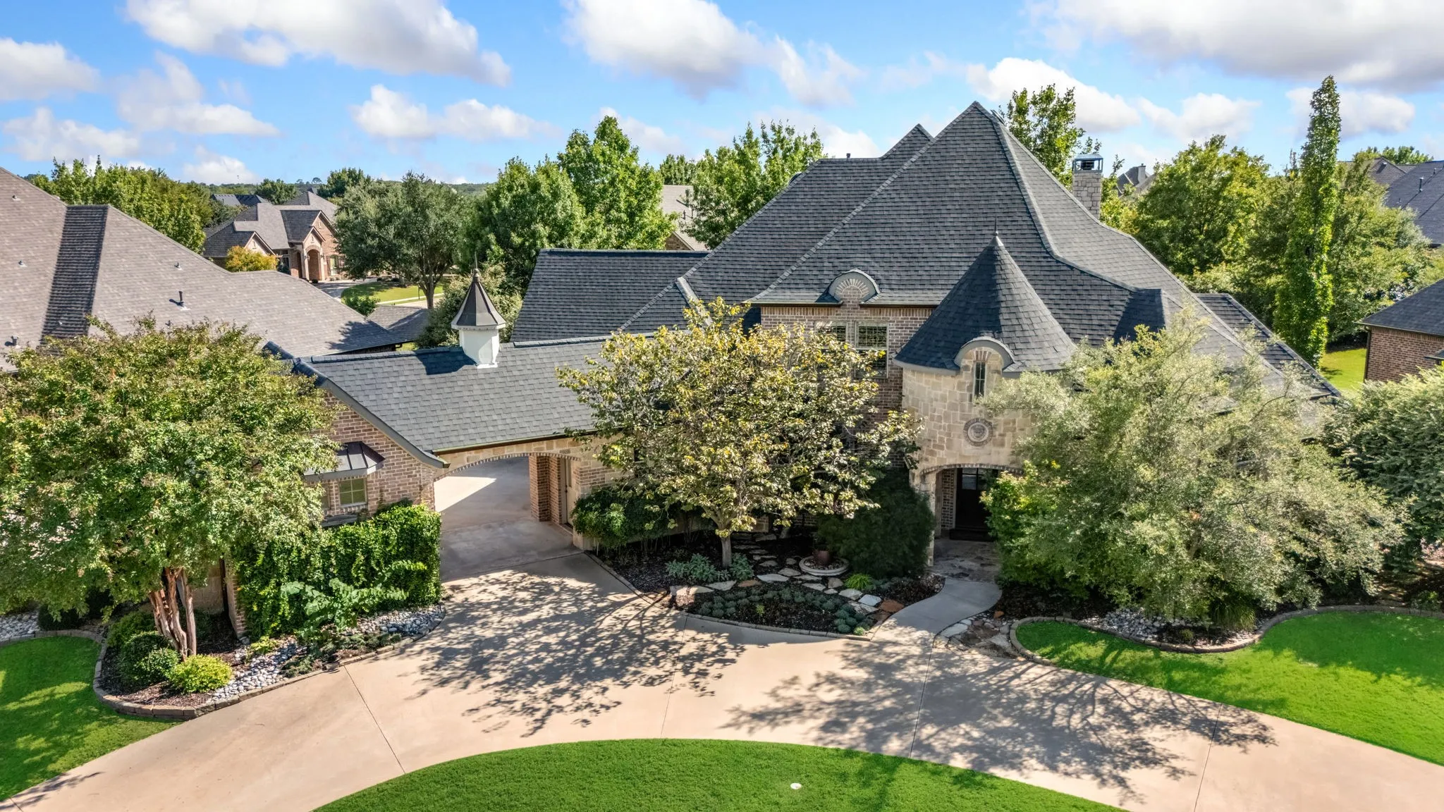 French country style house featuring brick siding, a chimney, and a front yard