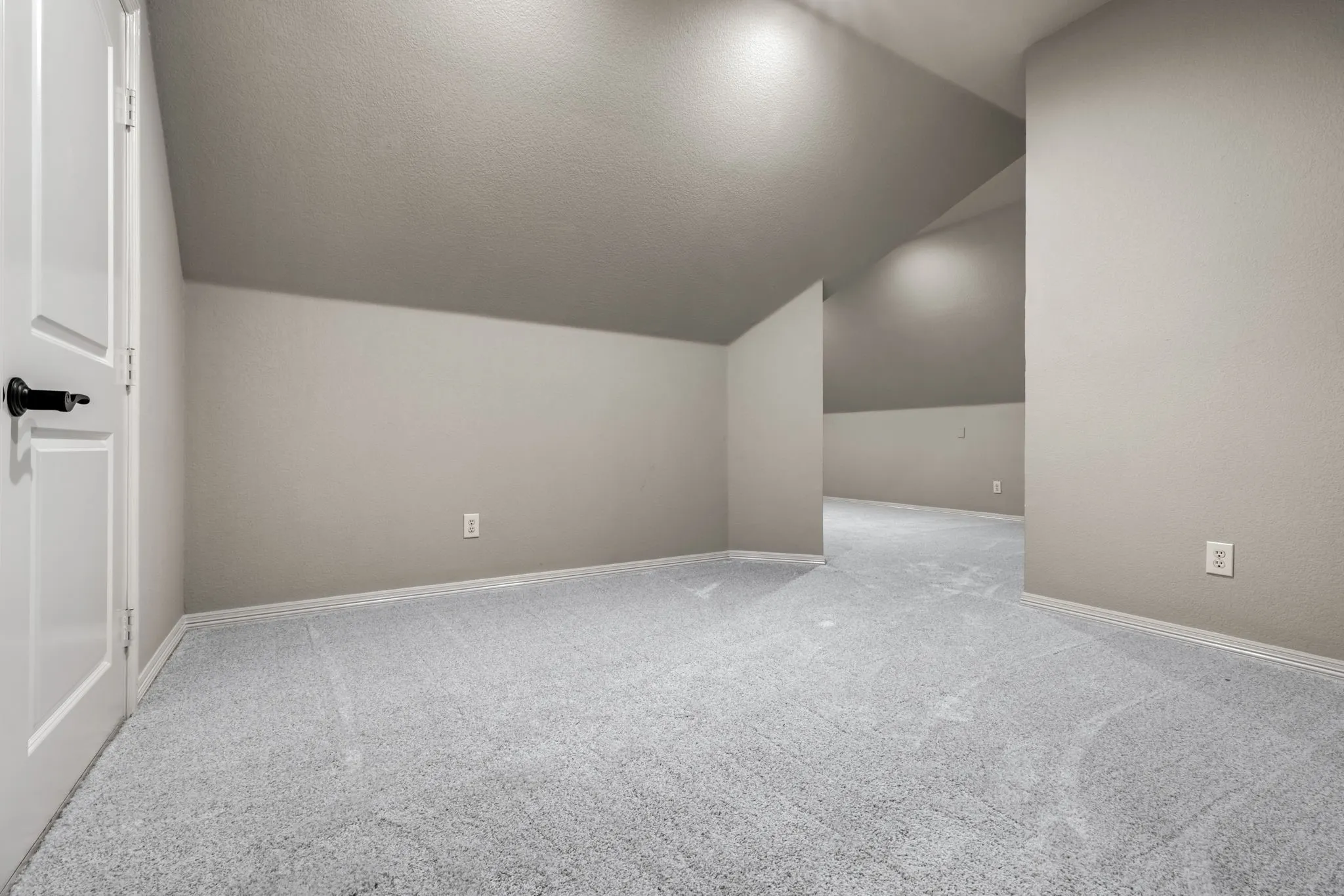 Bonus room with light carpet, lofted ceiling, and a textured ceiling