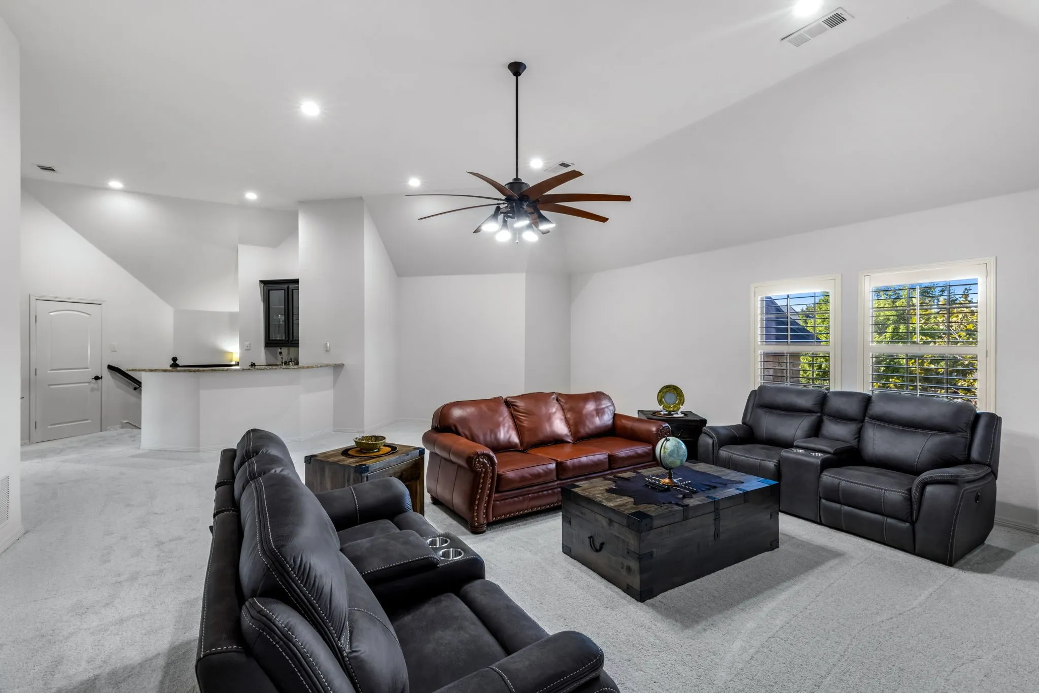 Carpeted living area featuring lofted ceiling, recessed lighting, and a ceiling fan
