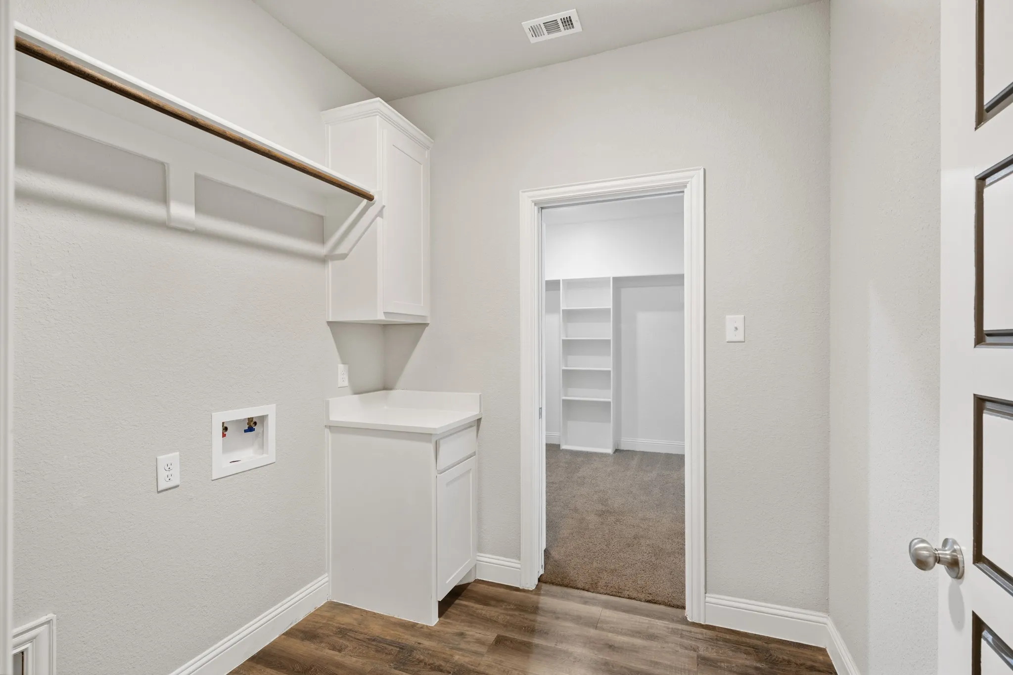 Laundry room has hall access and primary closet access.