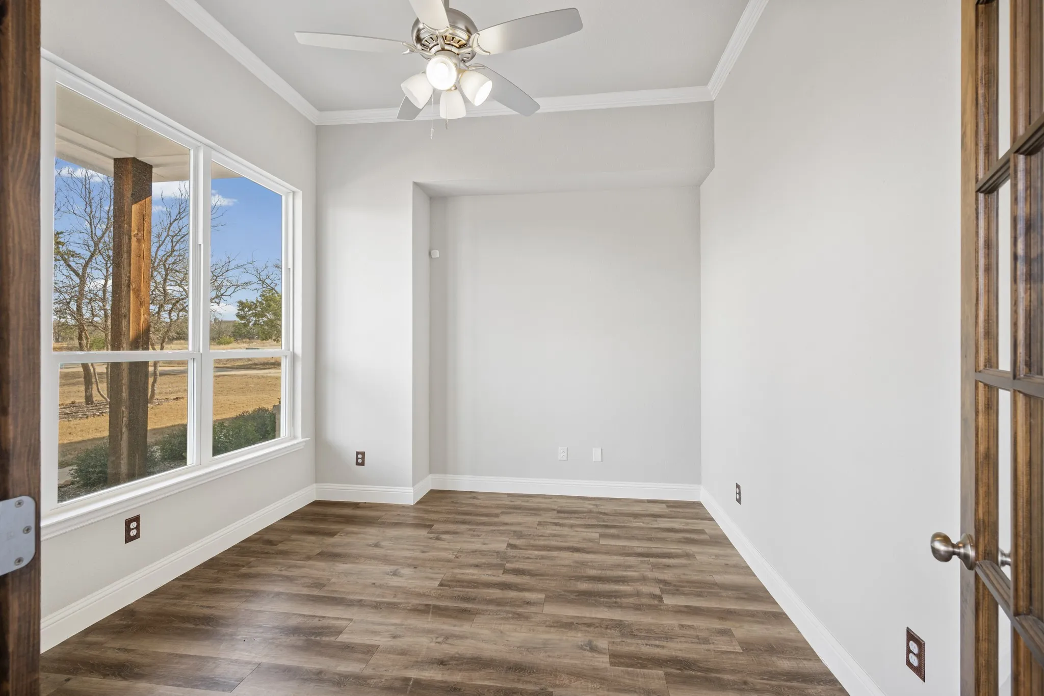 Light and bright office directly off the entryway features double glass doors and large windows.
