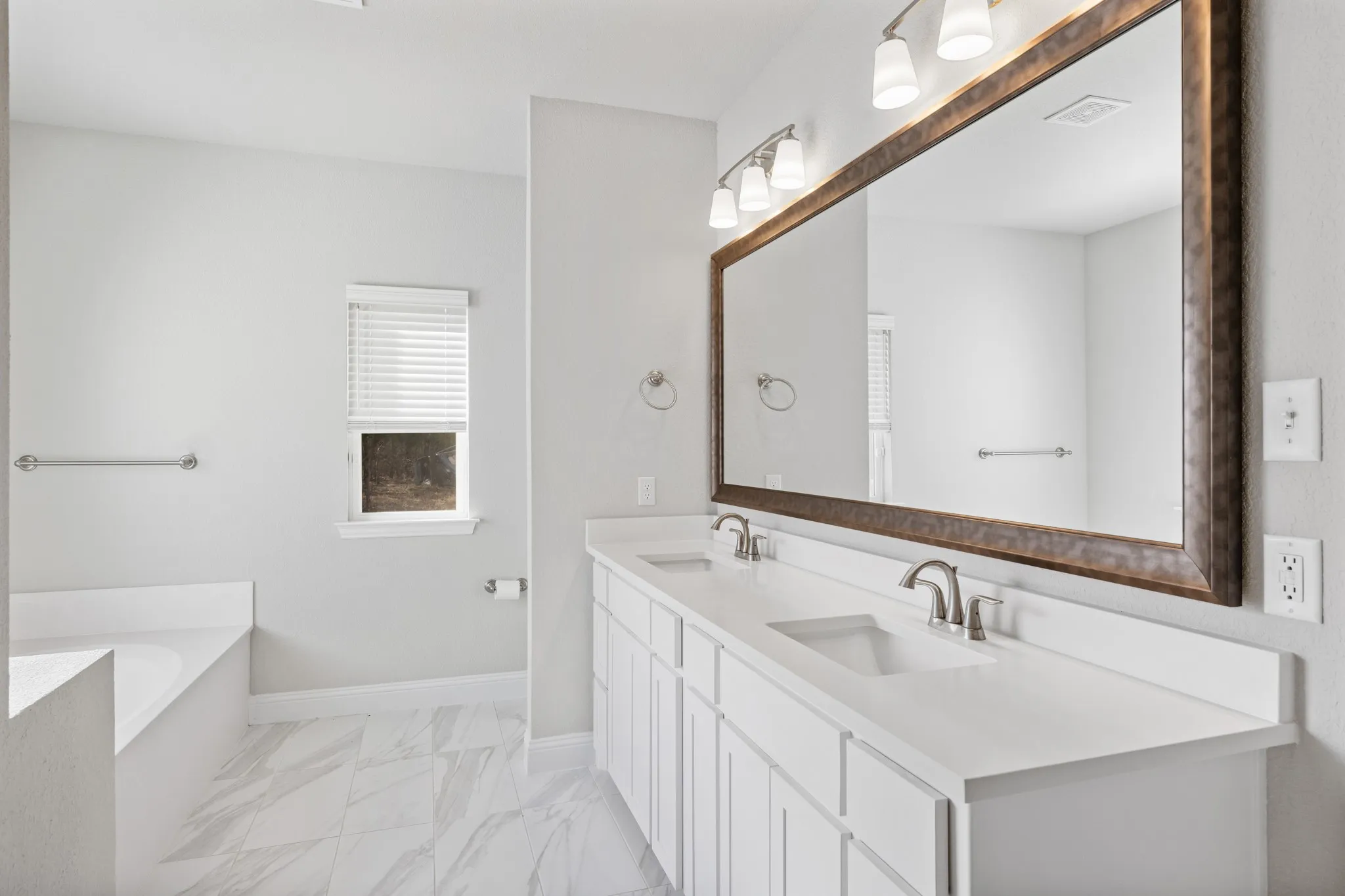 Dual sinks in primary bathroom with storage under the sinks.