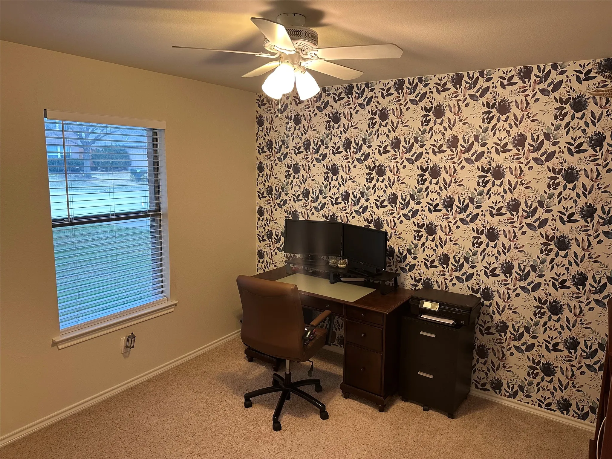 Office area featuring wallpapered walls, ceiling fan, and light colored carpet