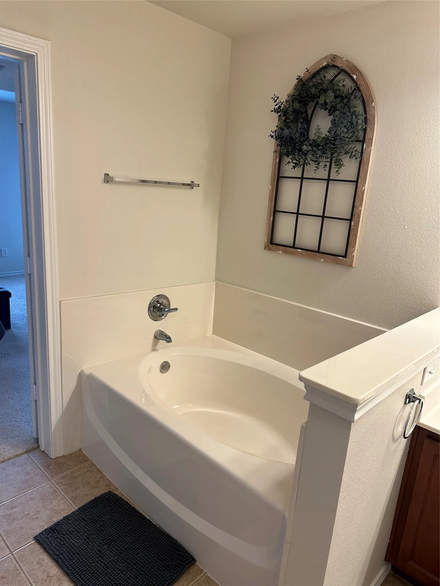 Bathroom with vanity, a garden tub, light tile patterned floors, and light carpet