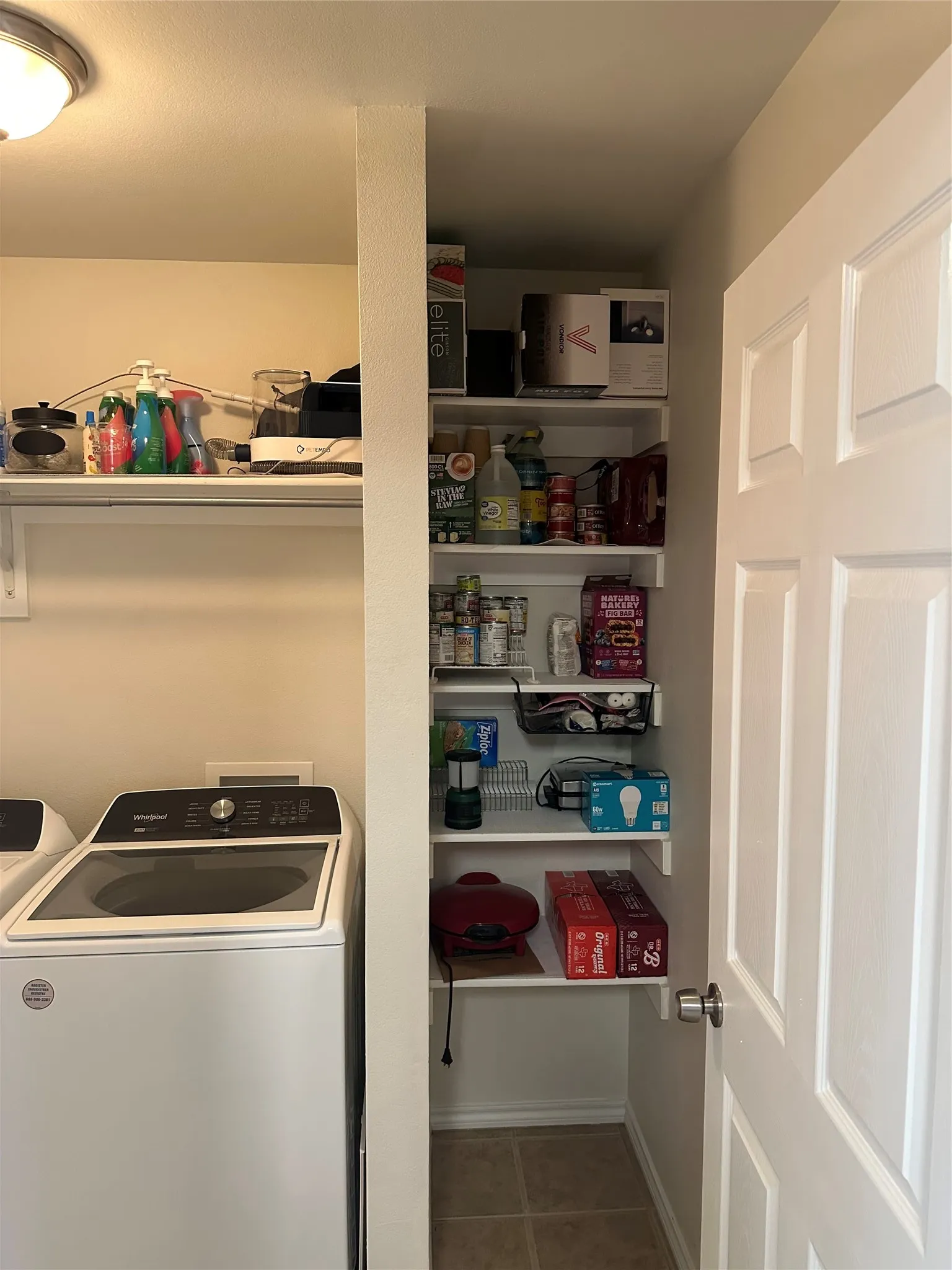 Laundry room with washer / dryer and dark tile patterned flooring
