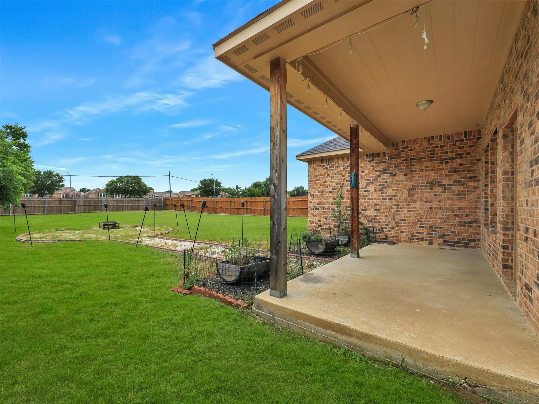 Fenced backyard with a patio area and a garden