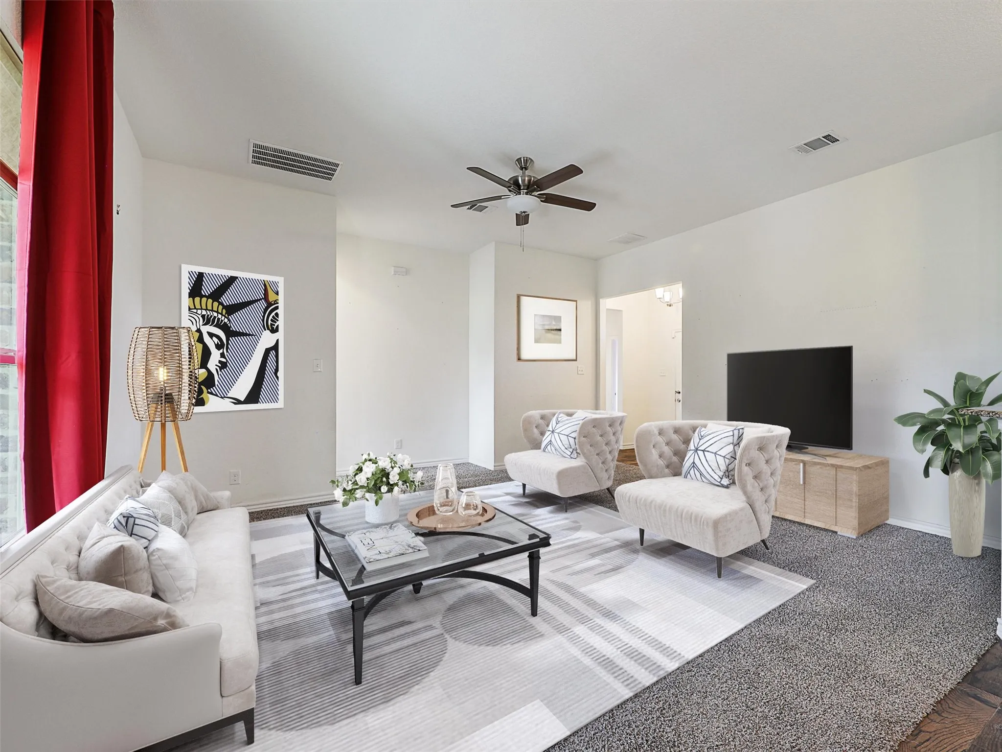 Carpeted living room with a ceiling fan and baseboards