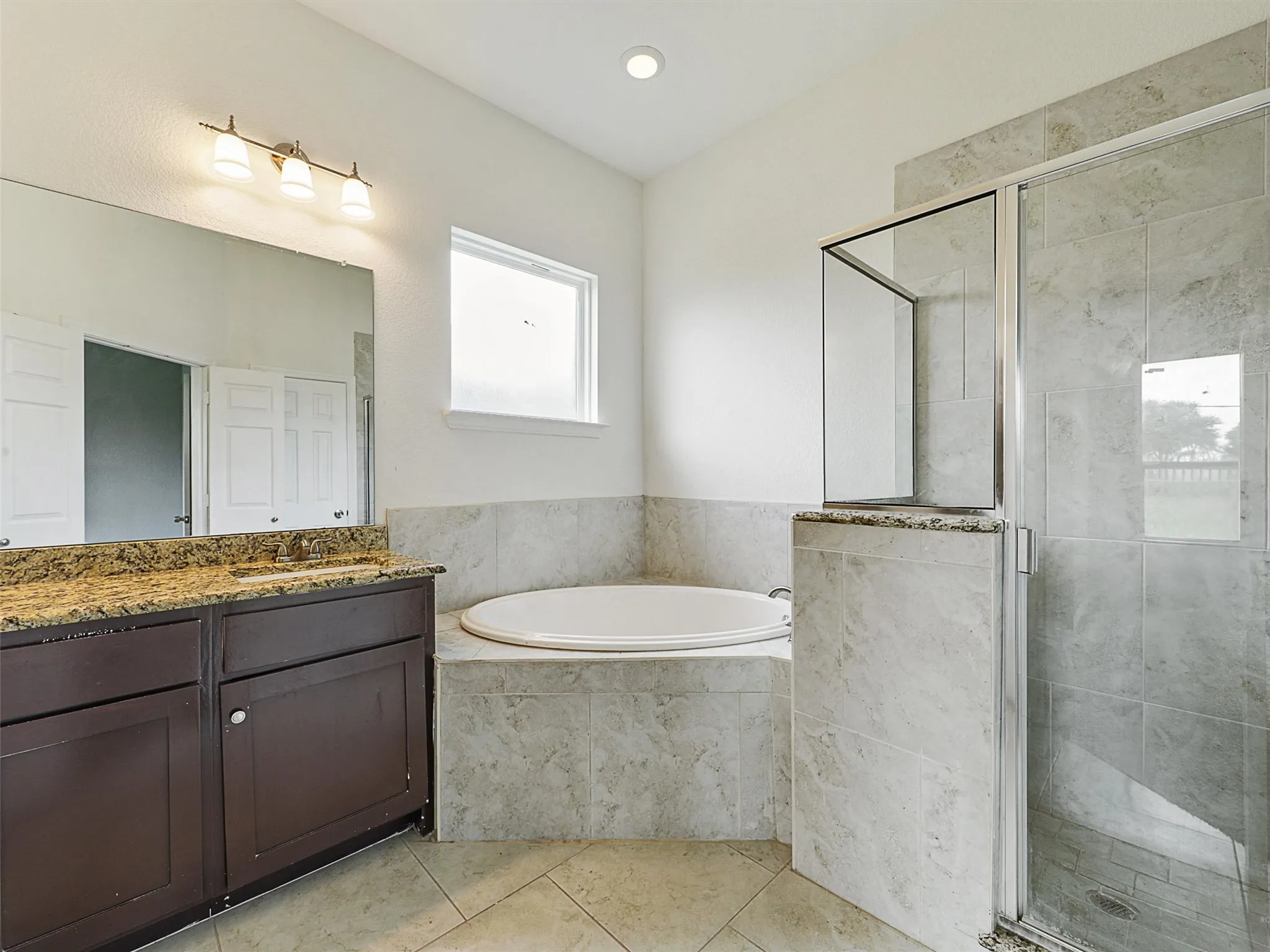 Full bathroom with vanity, a stall shower, a bath, and light tile patterned floors