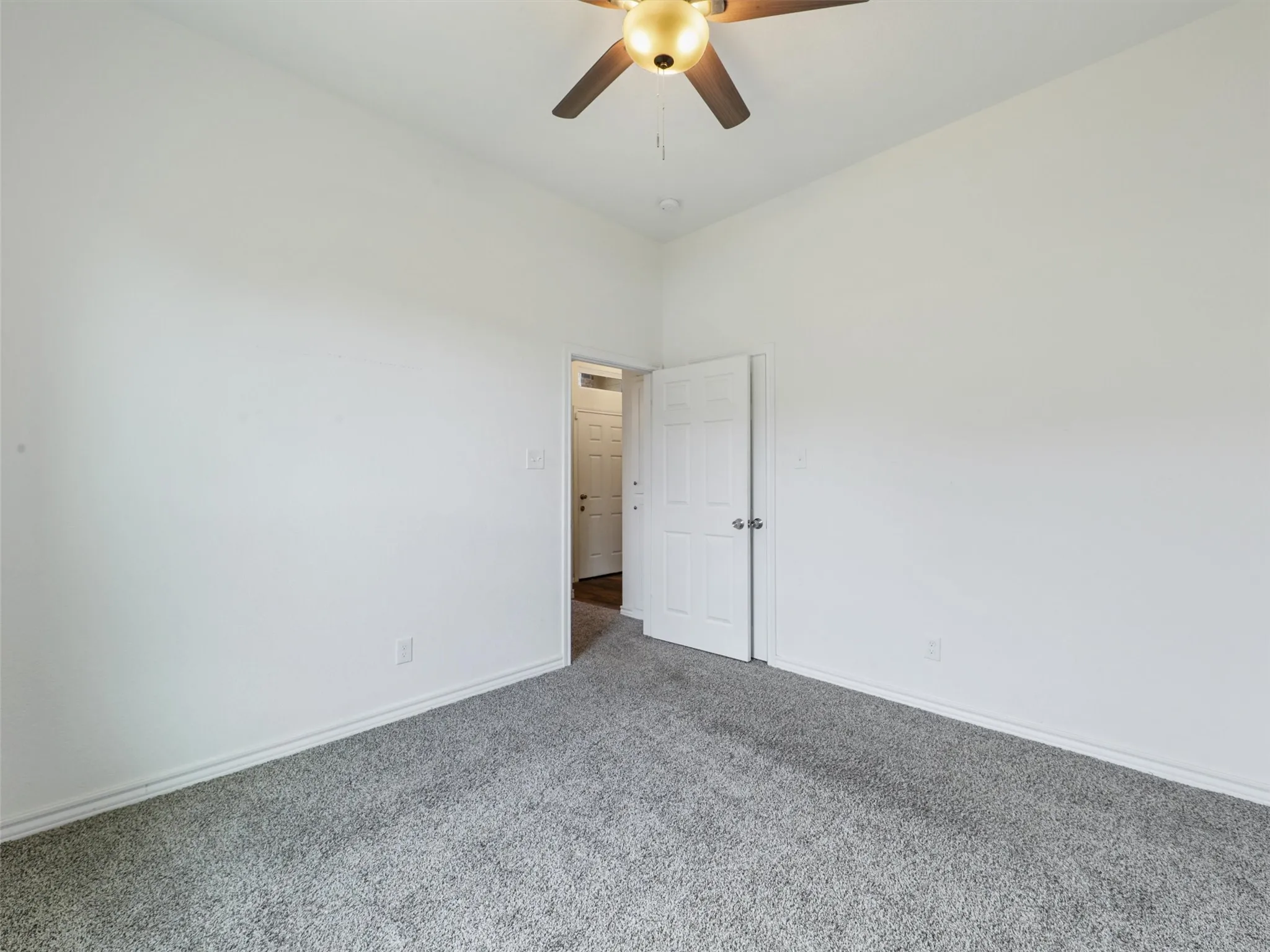 Spare room featuring carpet flooring and a ceiling fan