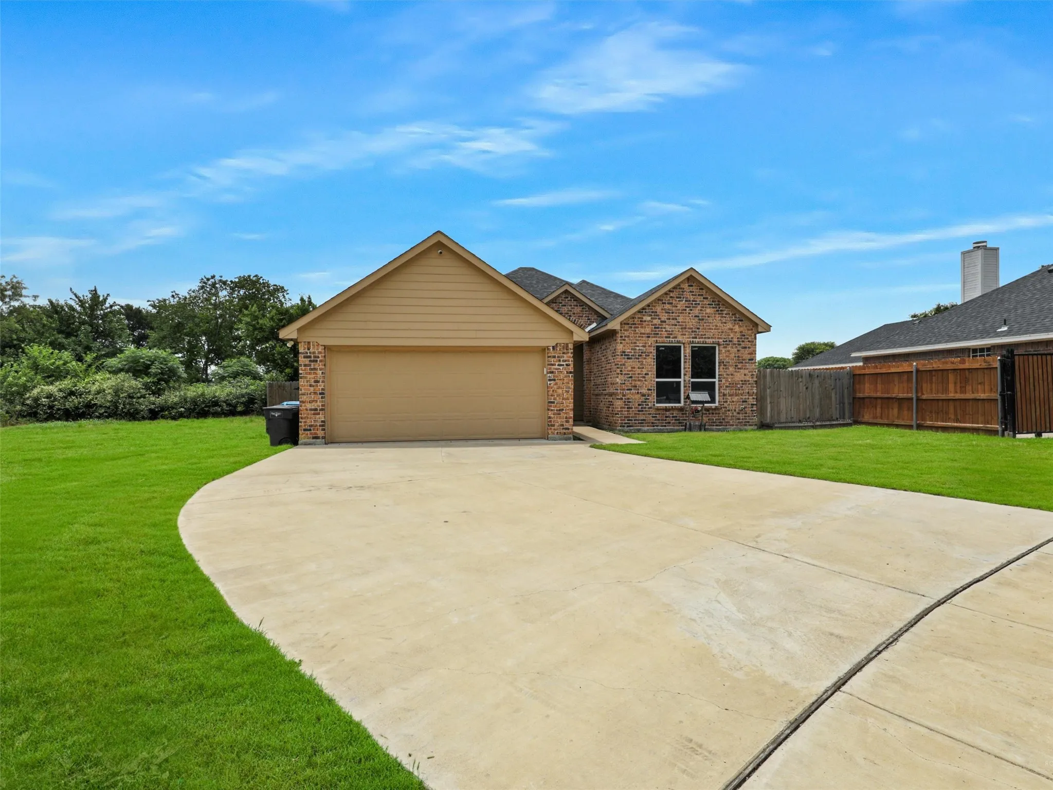 View of front of home featuring brick siding, driveway, and a garage