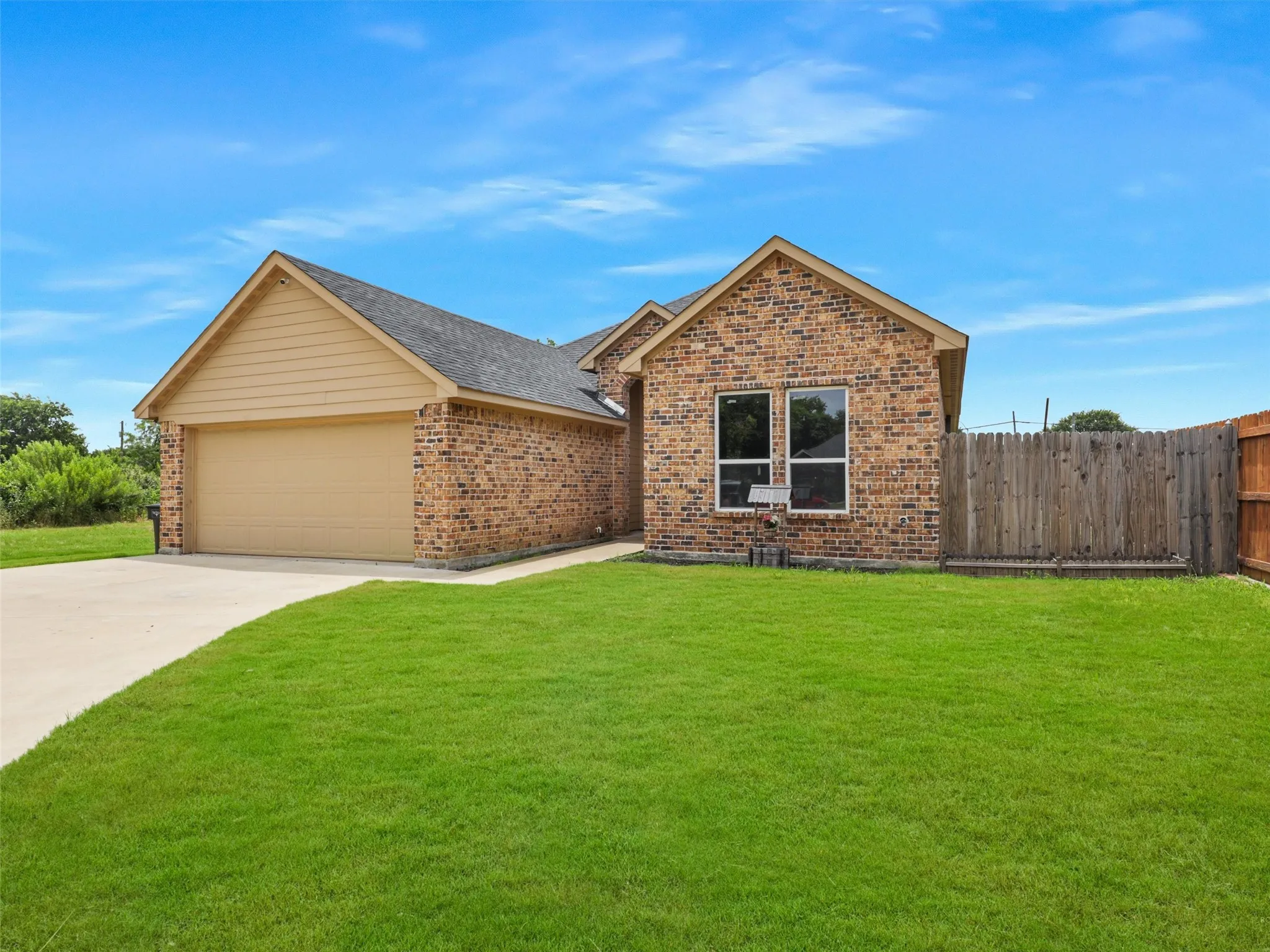 Single story home with brick siding, driveway, and a garage