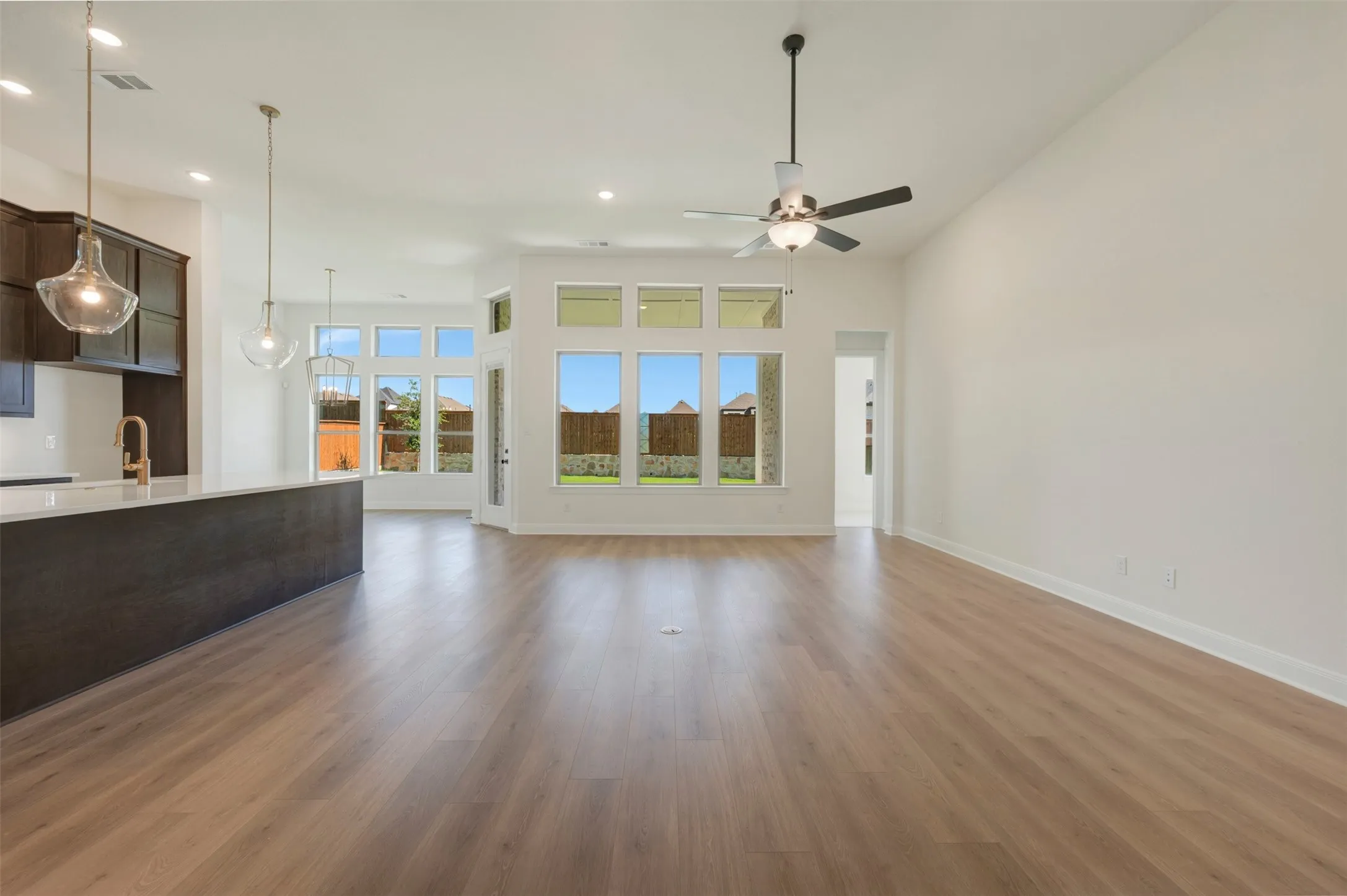 Spacious open-concept interior featuring light wood-finish flooring and high vaulted ceilings