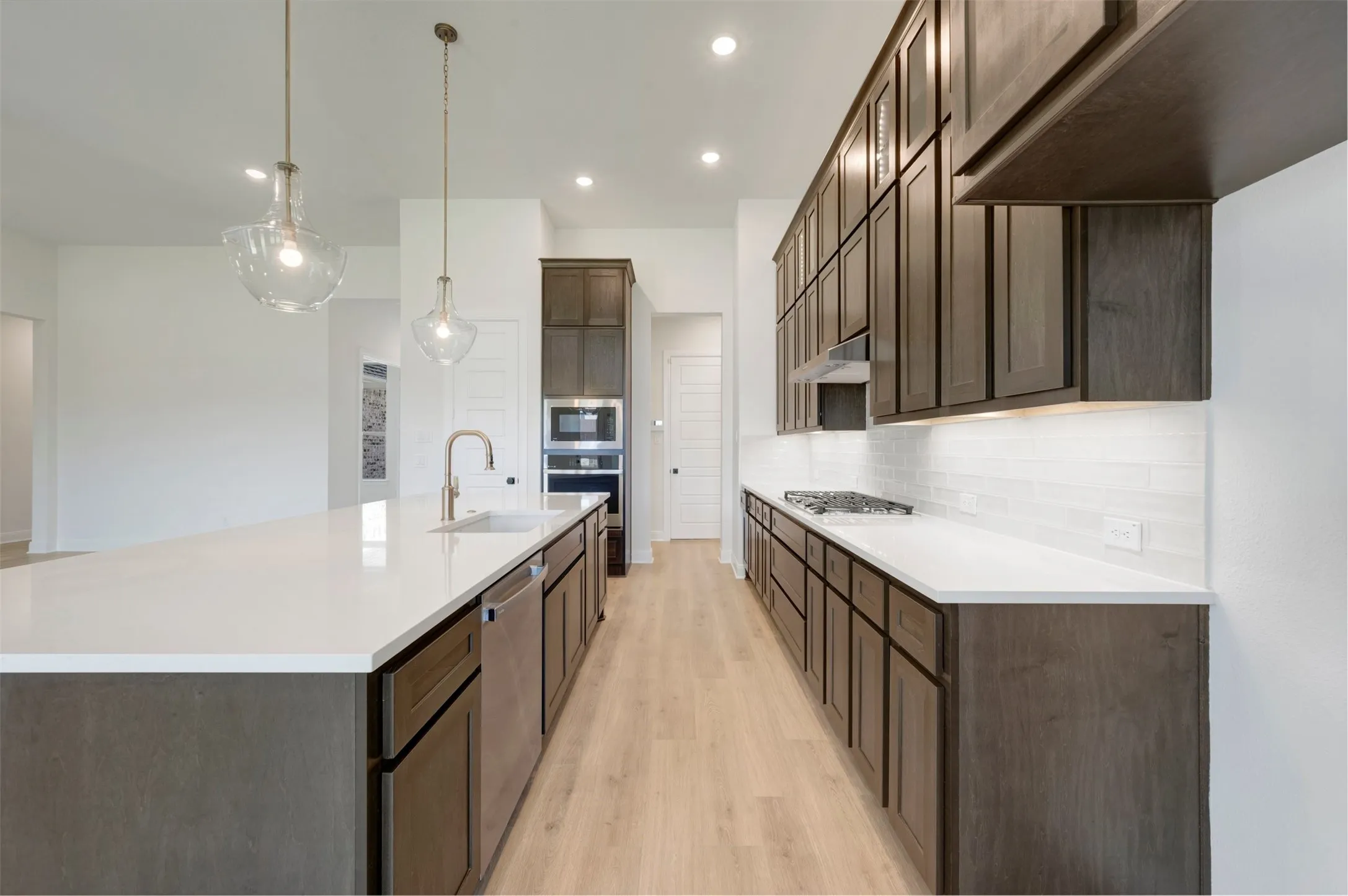 Kitchen featuring a large central island with a built-in sink and two pendant lights