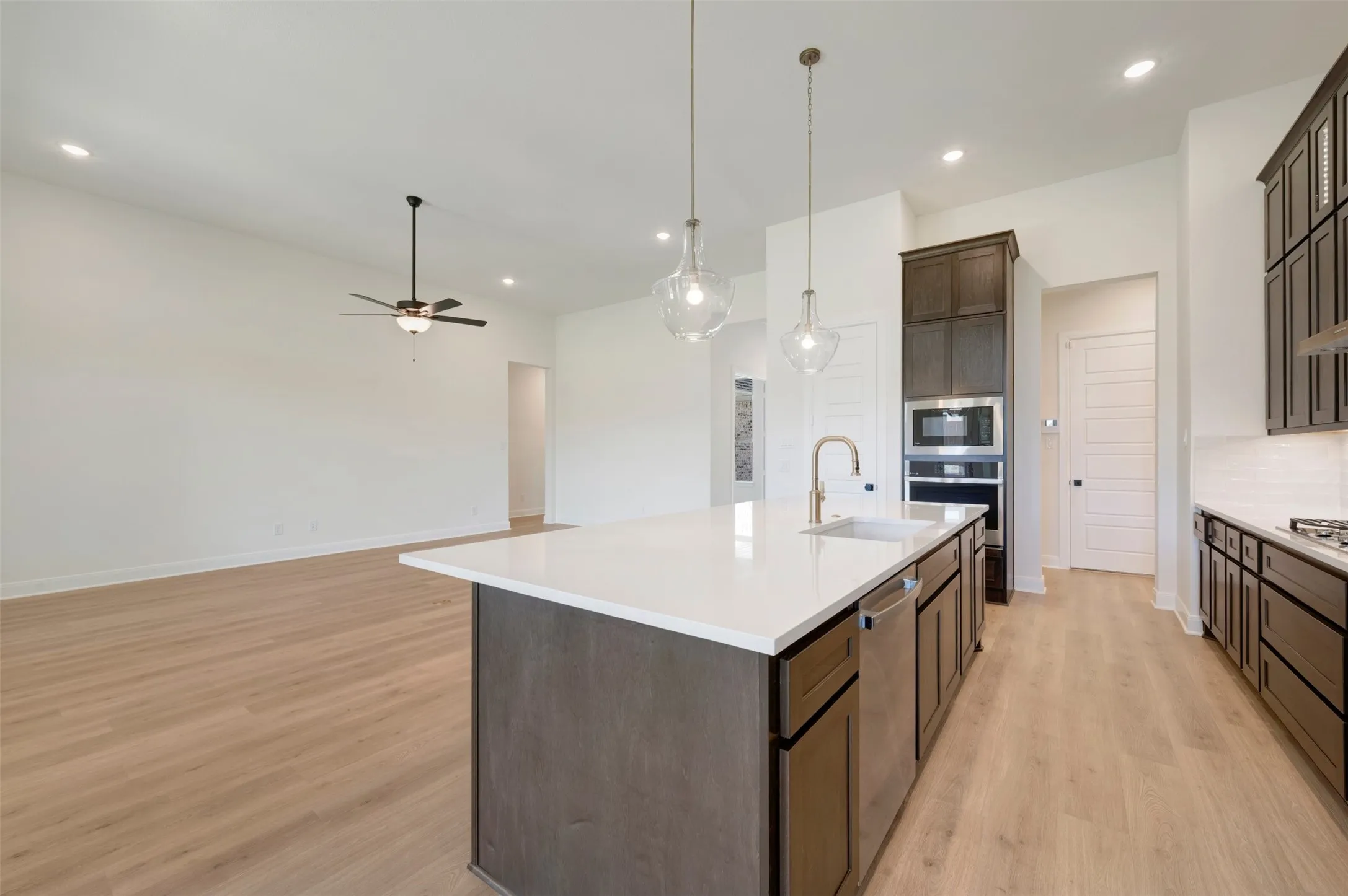 Kitchen island featuring a white countertop, undermount sink, and stainless steel dishwasher