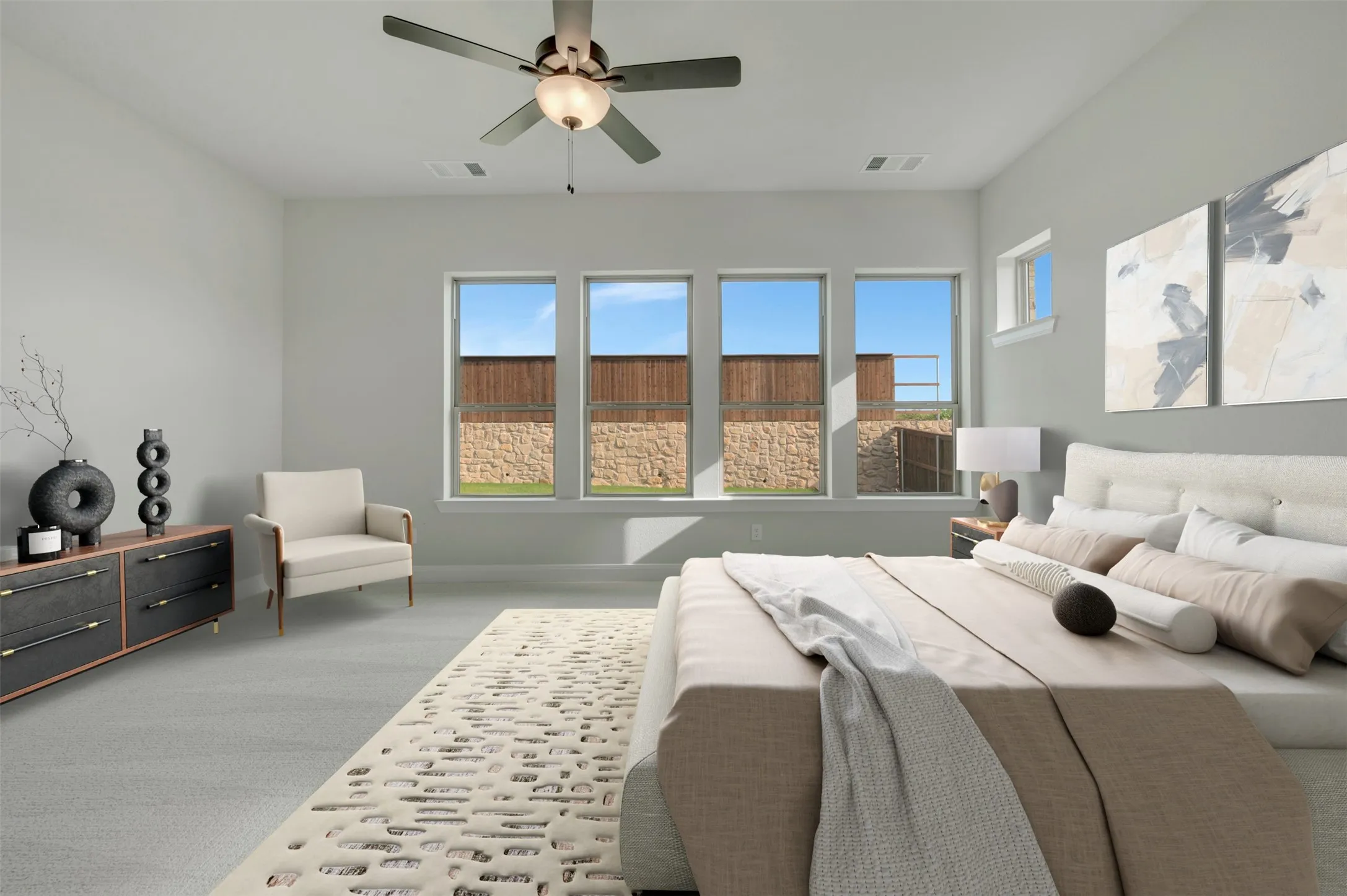 Spacious room featuring light gray carpeting, a ceiling fan with integrated lighting, and multiple windows
