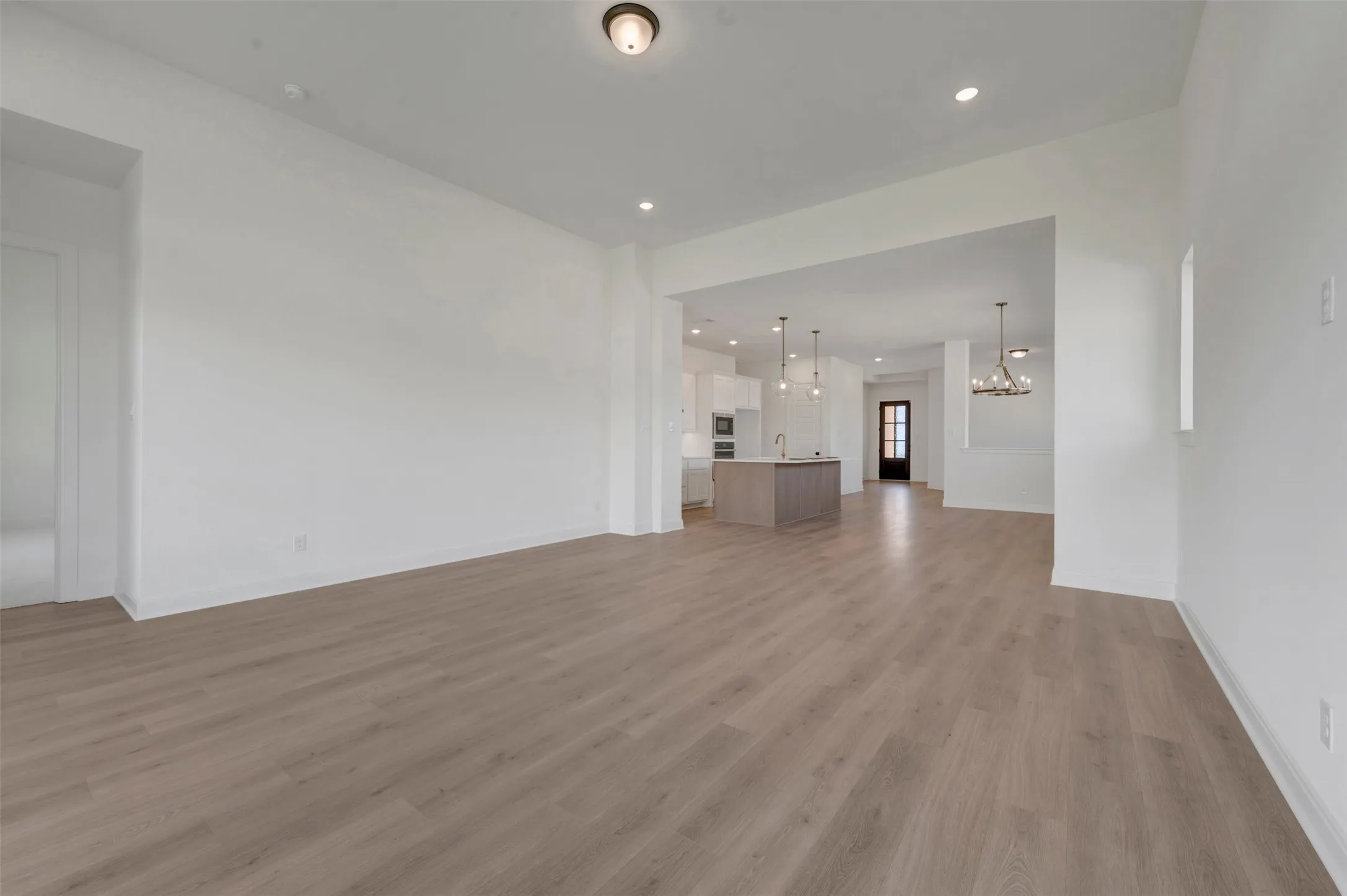 Open-concept living area featuring wood-finish flooring and recessed lighting
