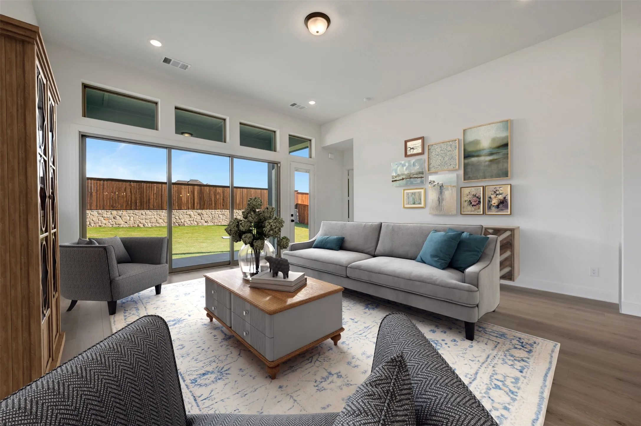 Bright living area featuring wood-finish flooring, a contemporary ceiling light fixture, and recessed lighting