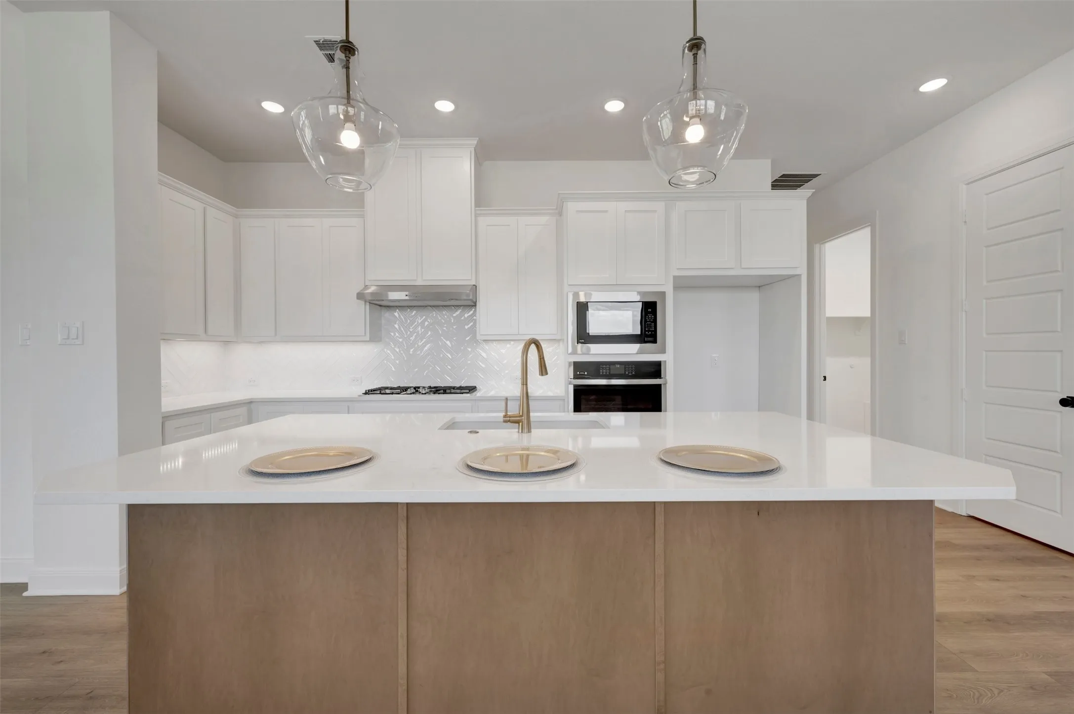 Kitchen featuring a central island with wood-finish paneling and a light-toned countertop