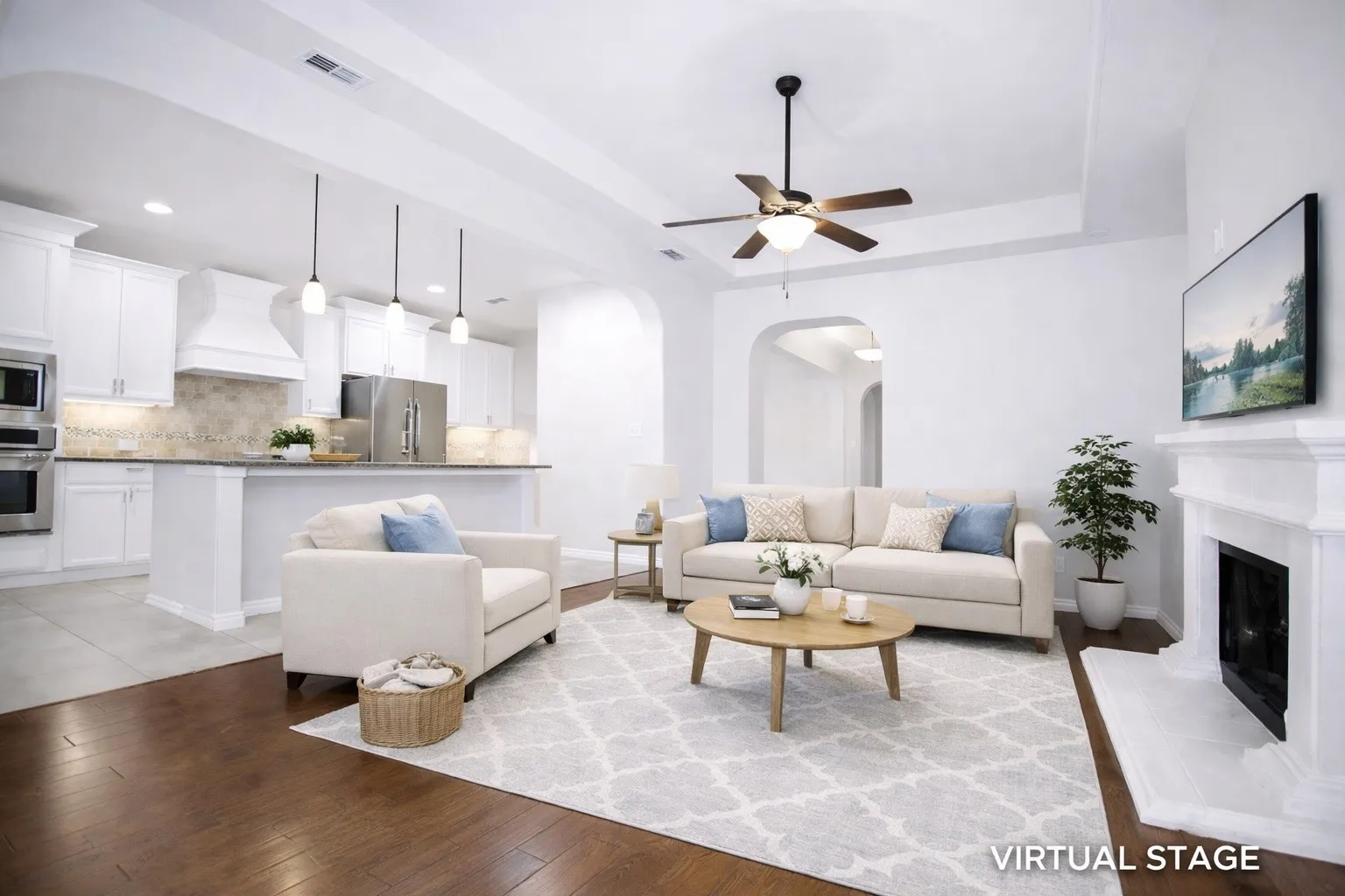 Virtual Staged Living room with light wood-style floors, a fireplace with raised hearth, a ceiling fan, arched walkways, and a raised ceiling