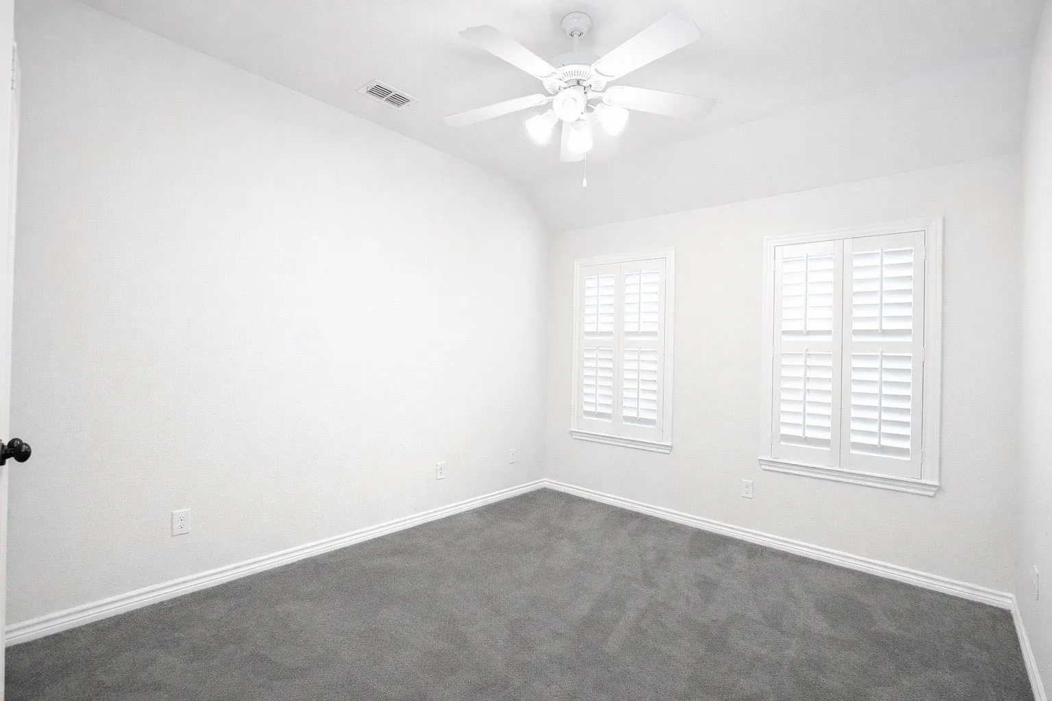 Unfurnished room with vaulted ceiling, ceiling fan, and dark carpet