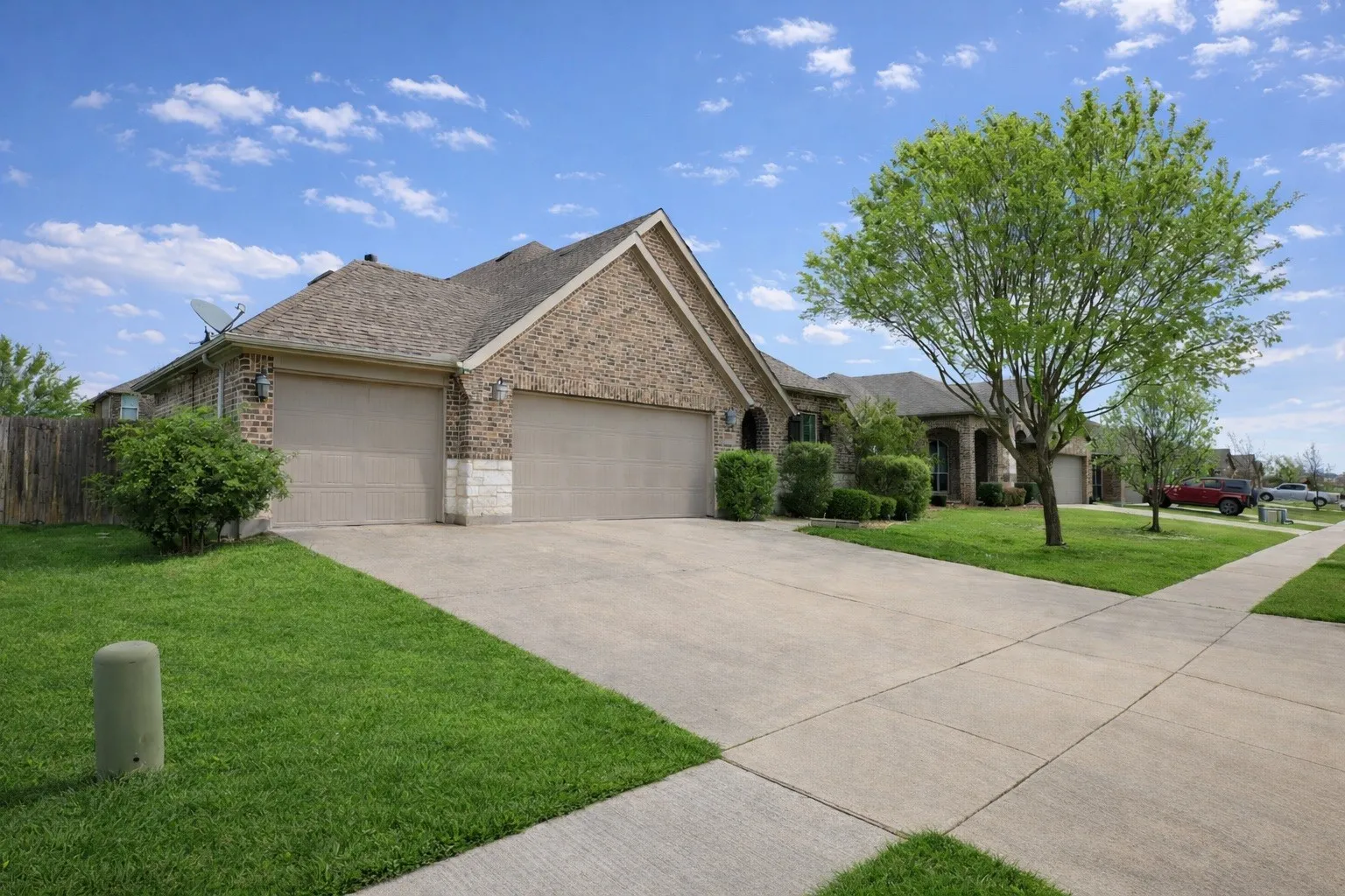 Ranch-style home with an attached garage, brick siding, driveway, and a shingled roof