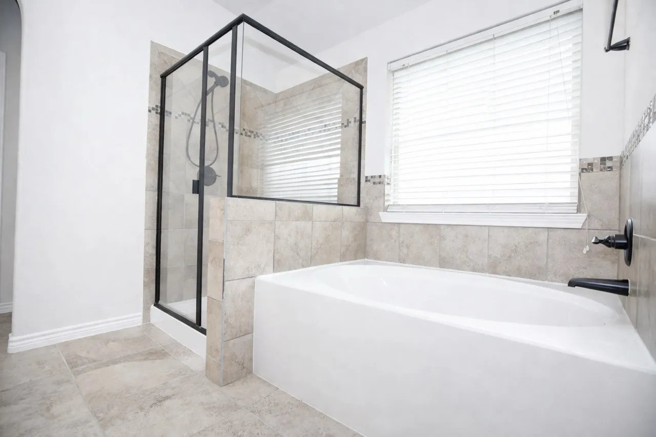 Bathroom featuring a garden tub and a shower stall