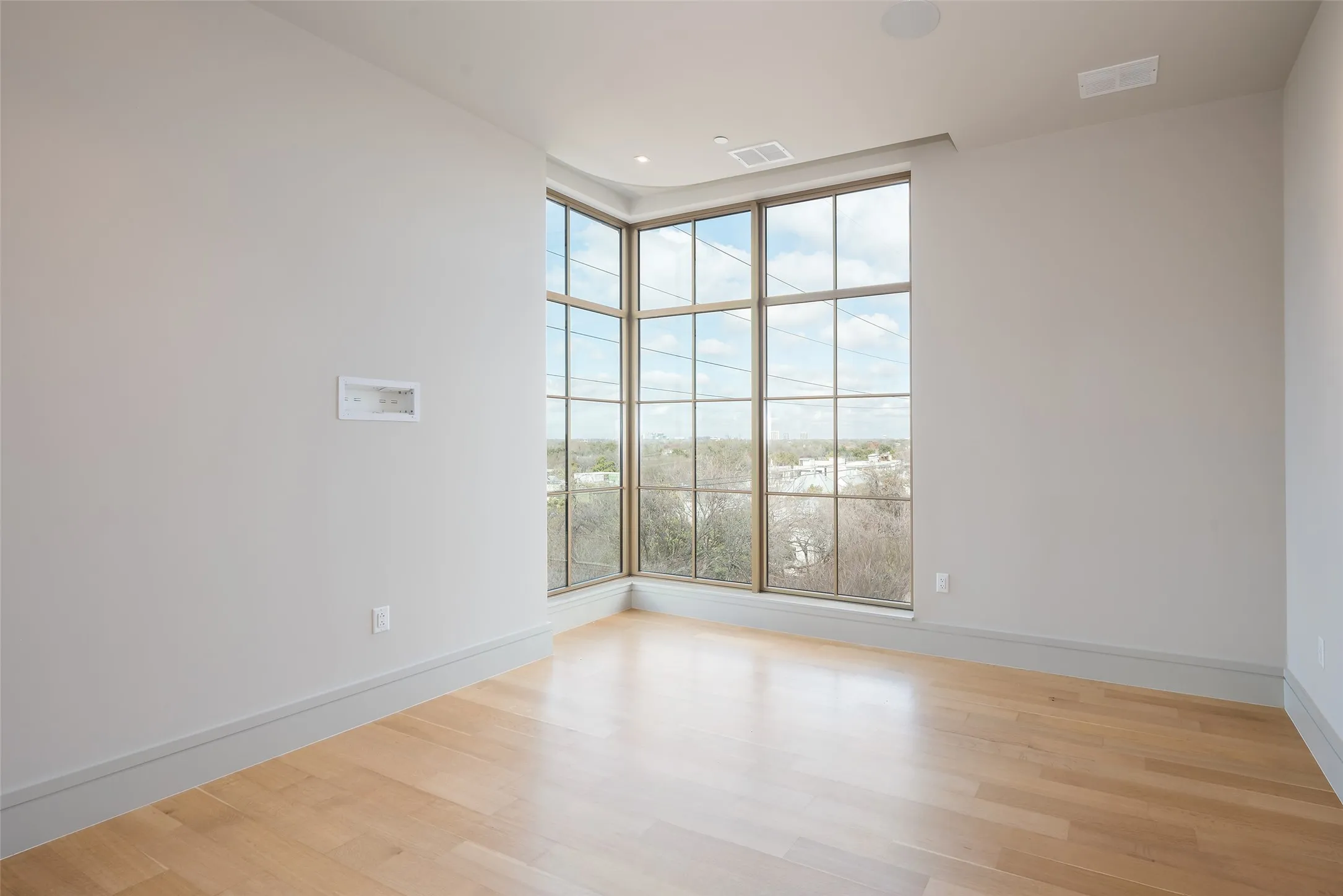Empty room with light wood finished floors and baseboards