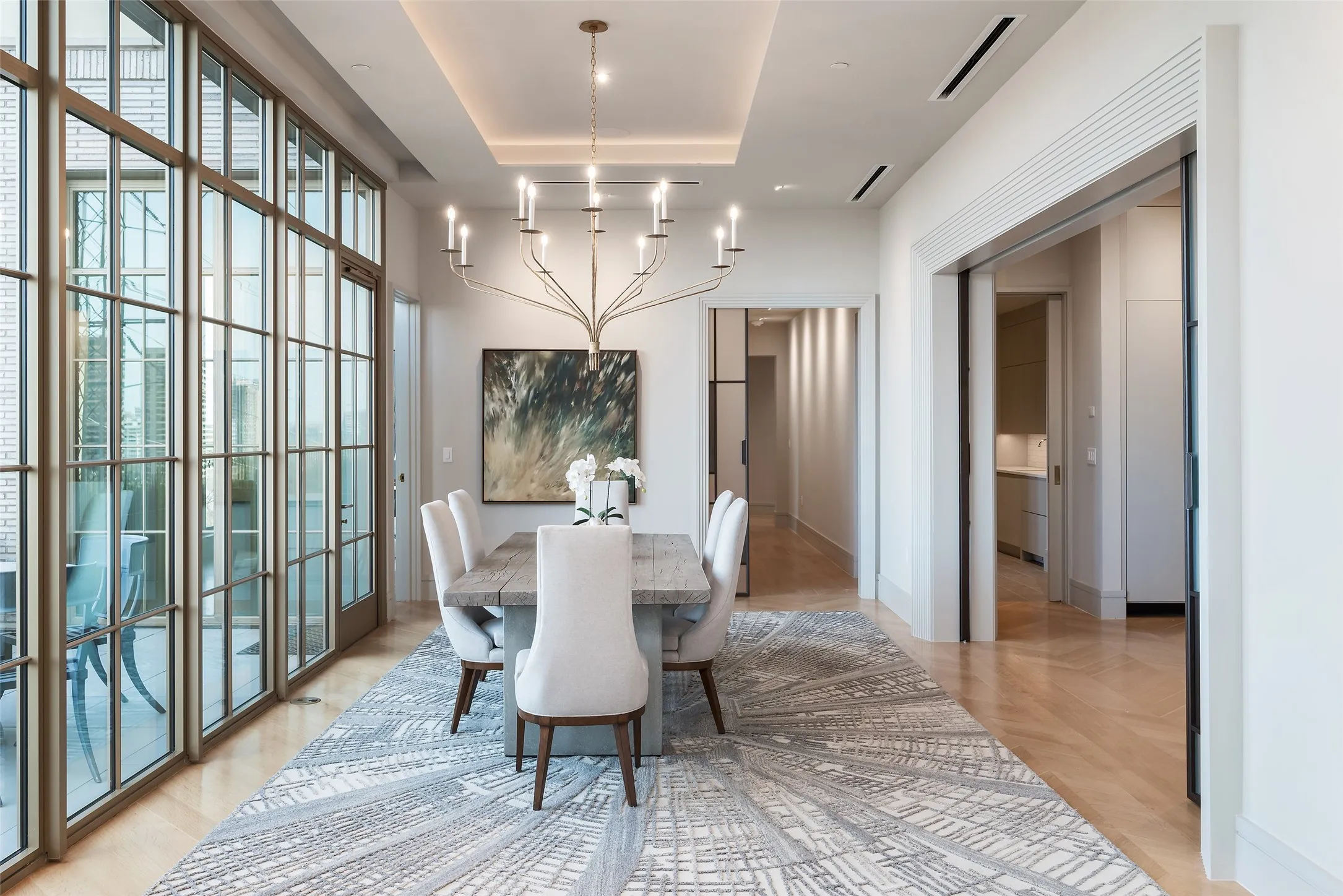 Dining space featuring light wood-style flooring, a tray ceiling, and suspended lighting