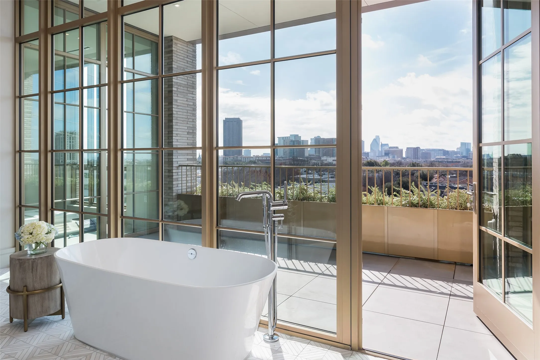 Bathroom featuring plenty of natural light, a skyline view, a freestanding tub, and floor to ceiling windows