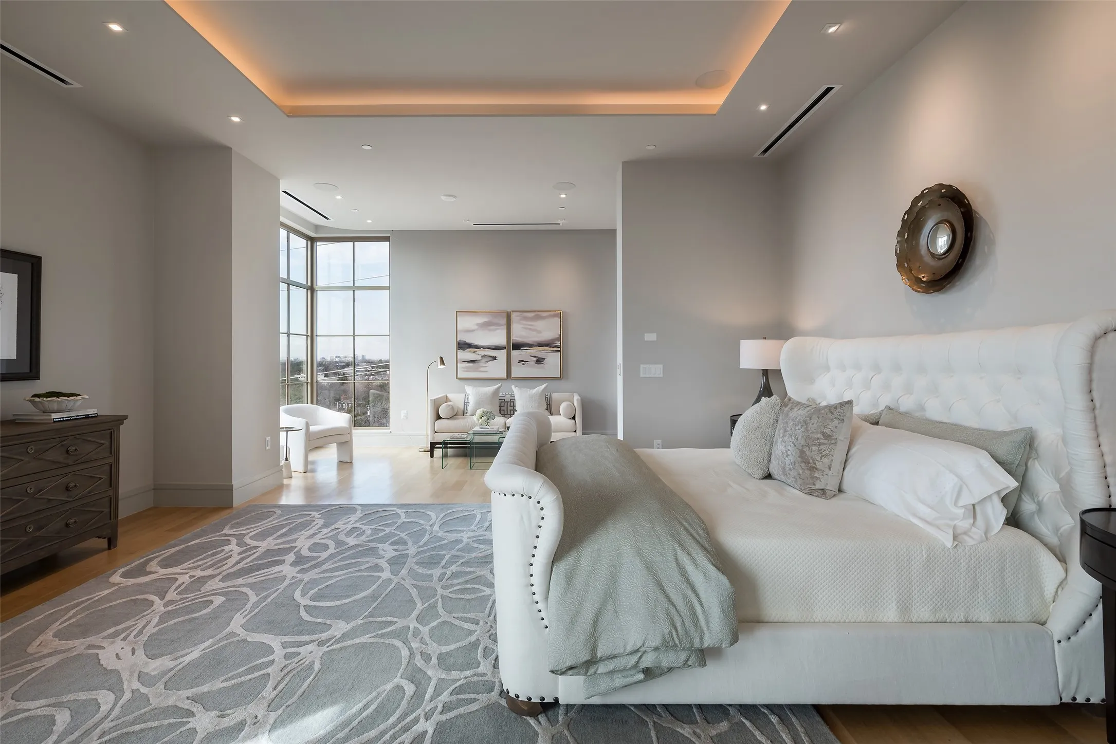 Bedroom featuring expansive windows, light wood-style flooring, a tray ceiling, and recessed lighting