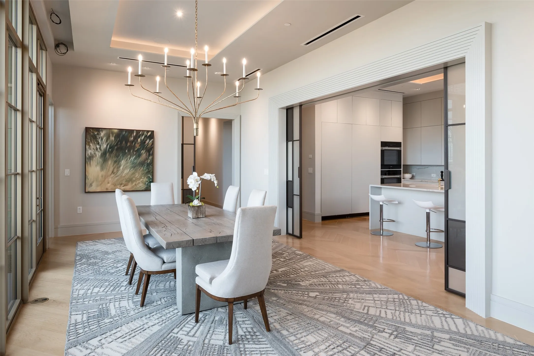 Dining room featuring light wood-type flooring, a raised ceiling, and hanging lights