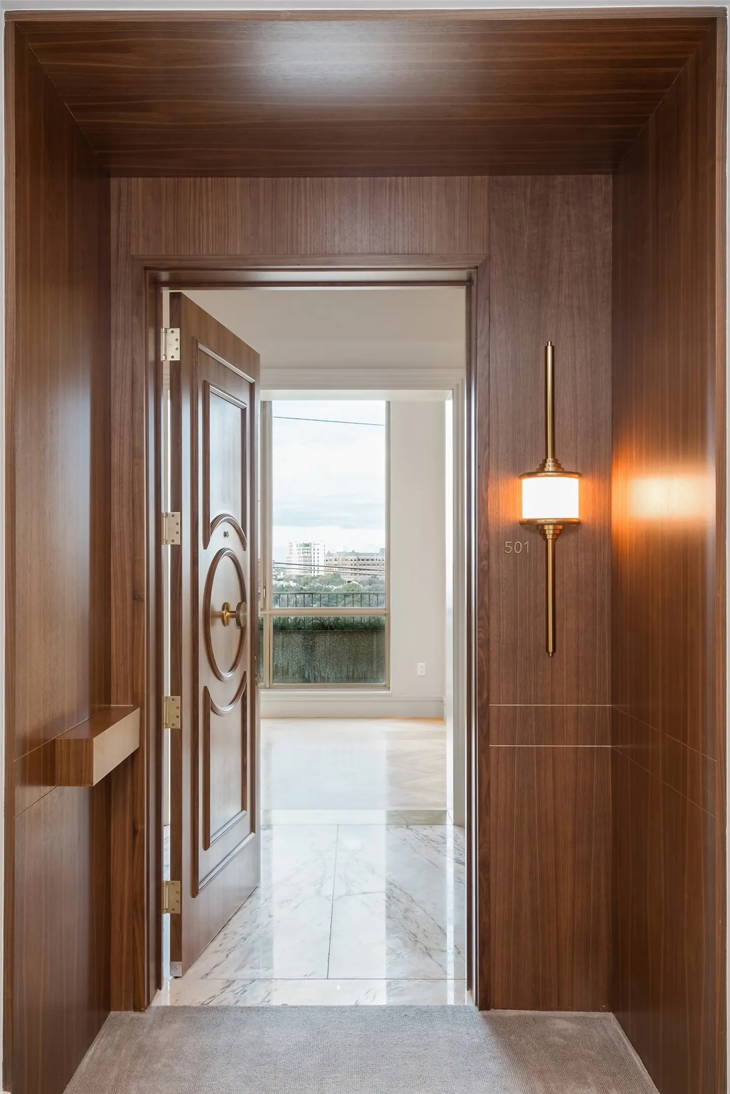 Hall with light marble finish floors and wood walls