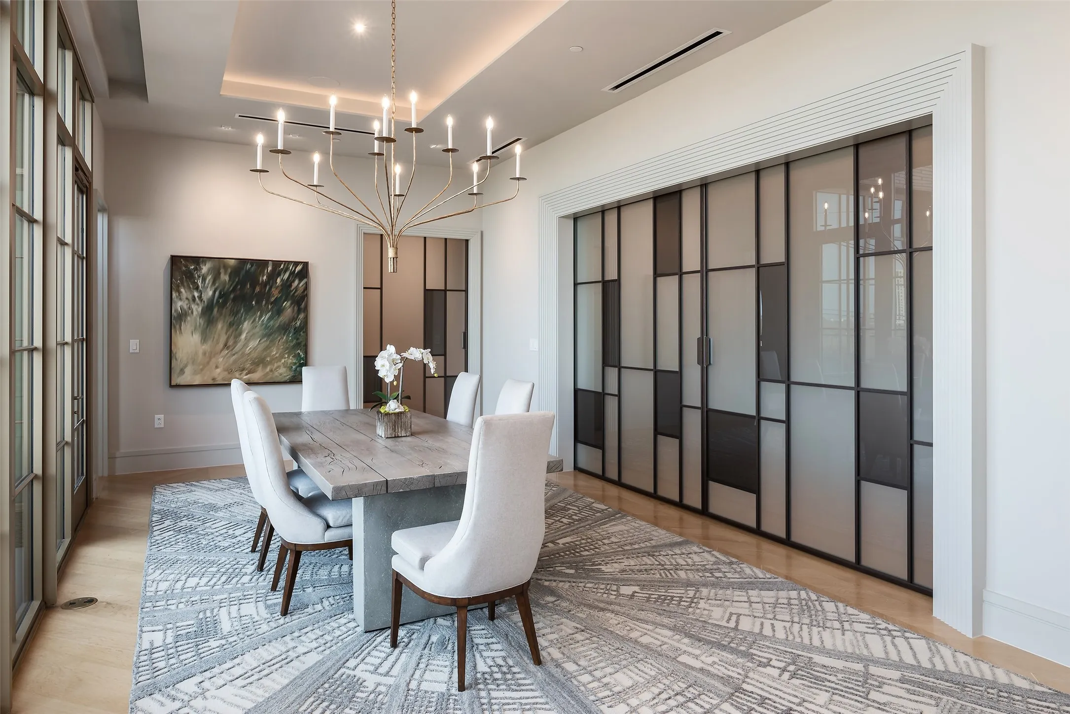 Dining area featuring a raised ceiling, hanging lights, and light wood-style flooring