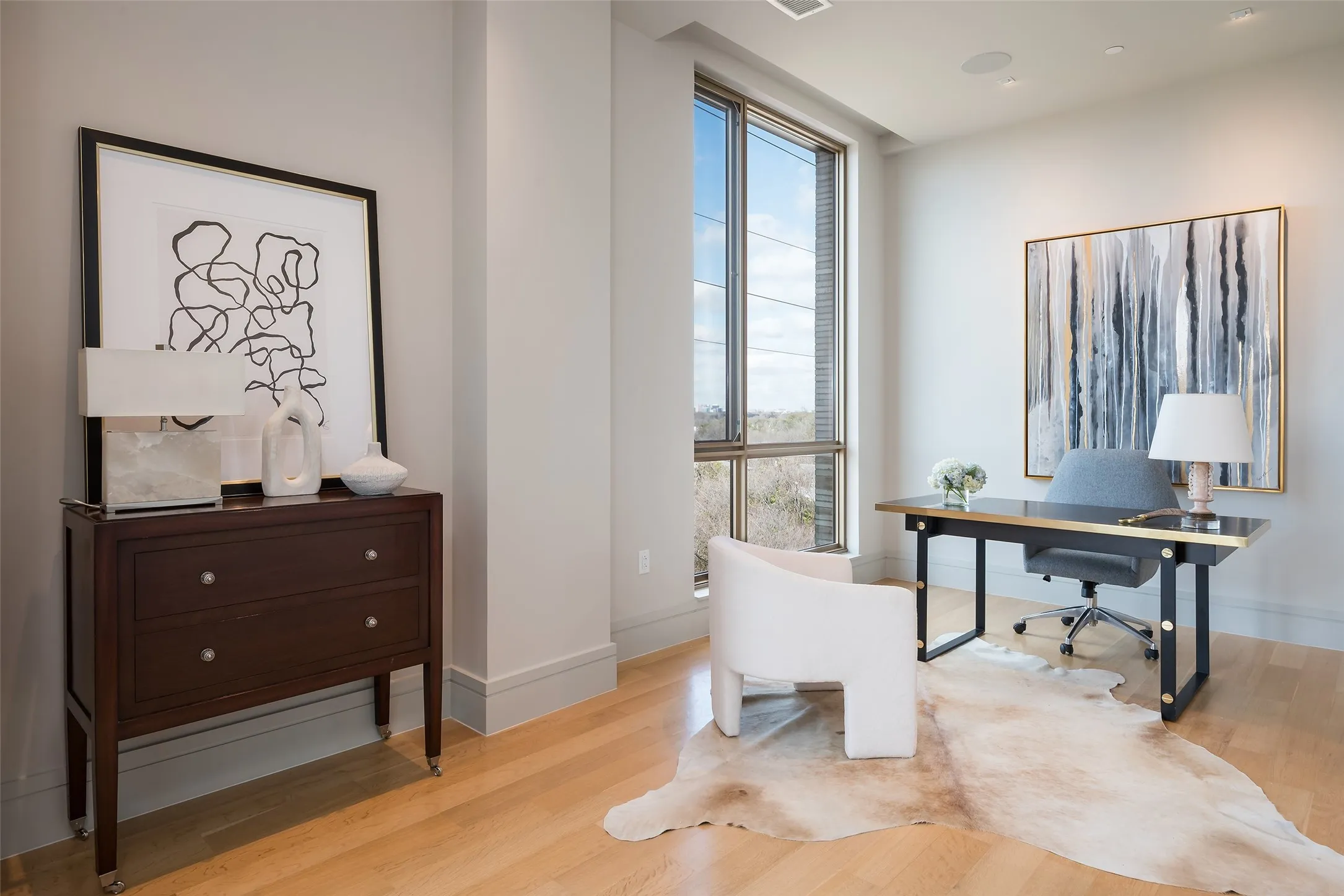 Office area with light wood-style floors and floor to ceiling windows